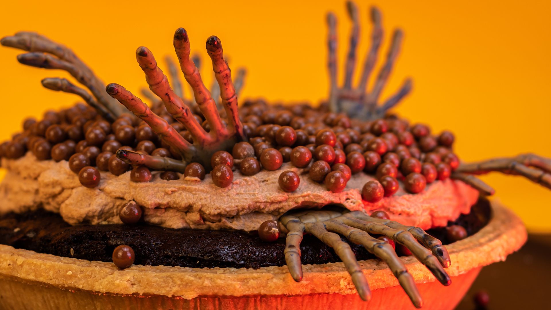 A pie with skeleton hands sticking out of it