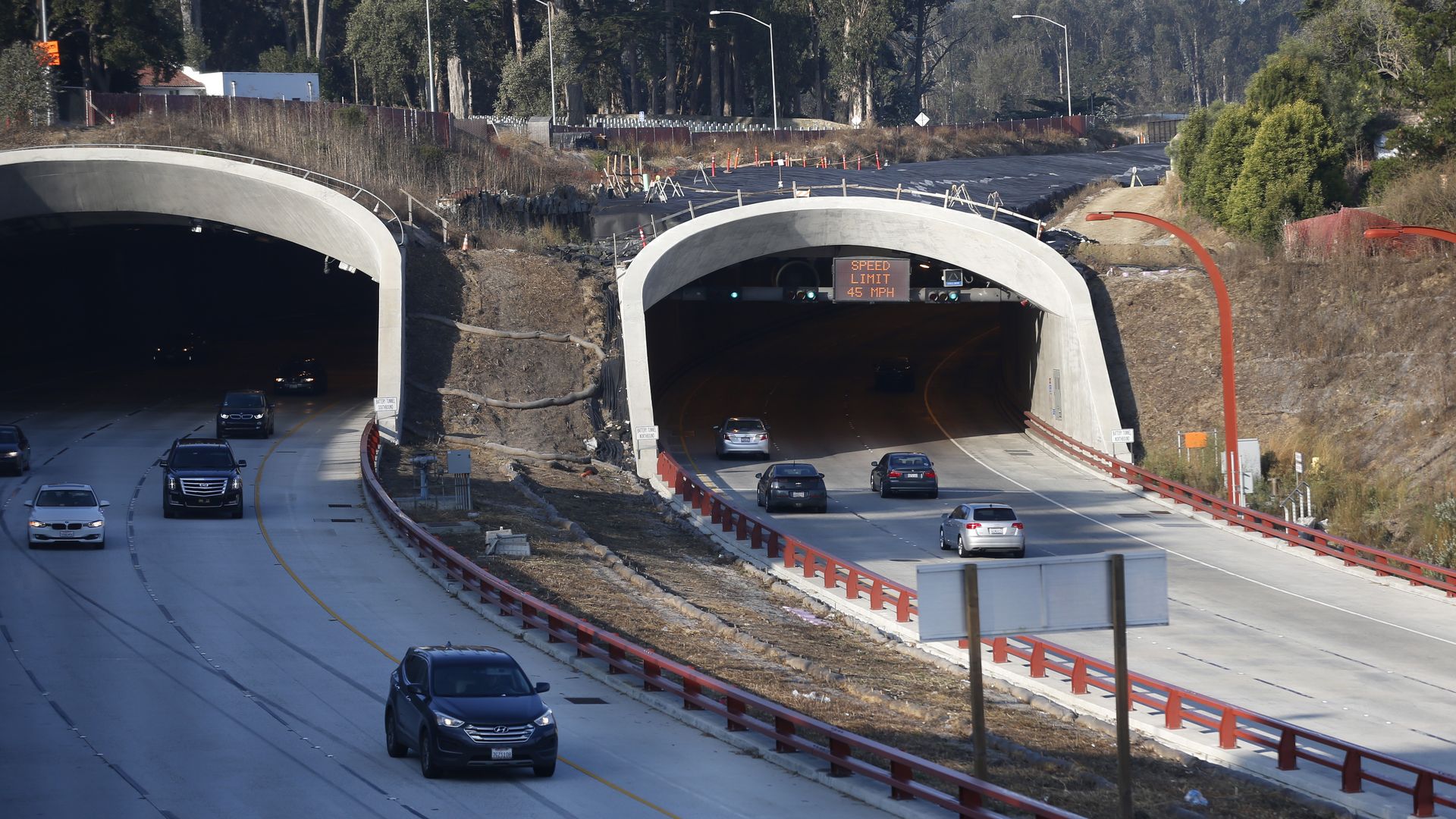 Photo of cars coming out of a tunnel as construction continues on the land over the tunnel/expressway