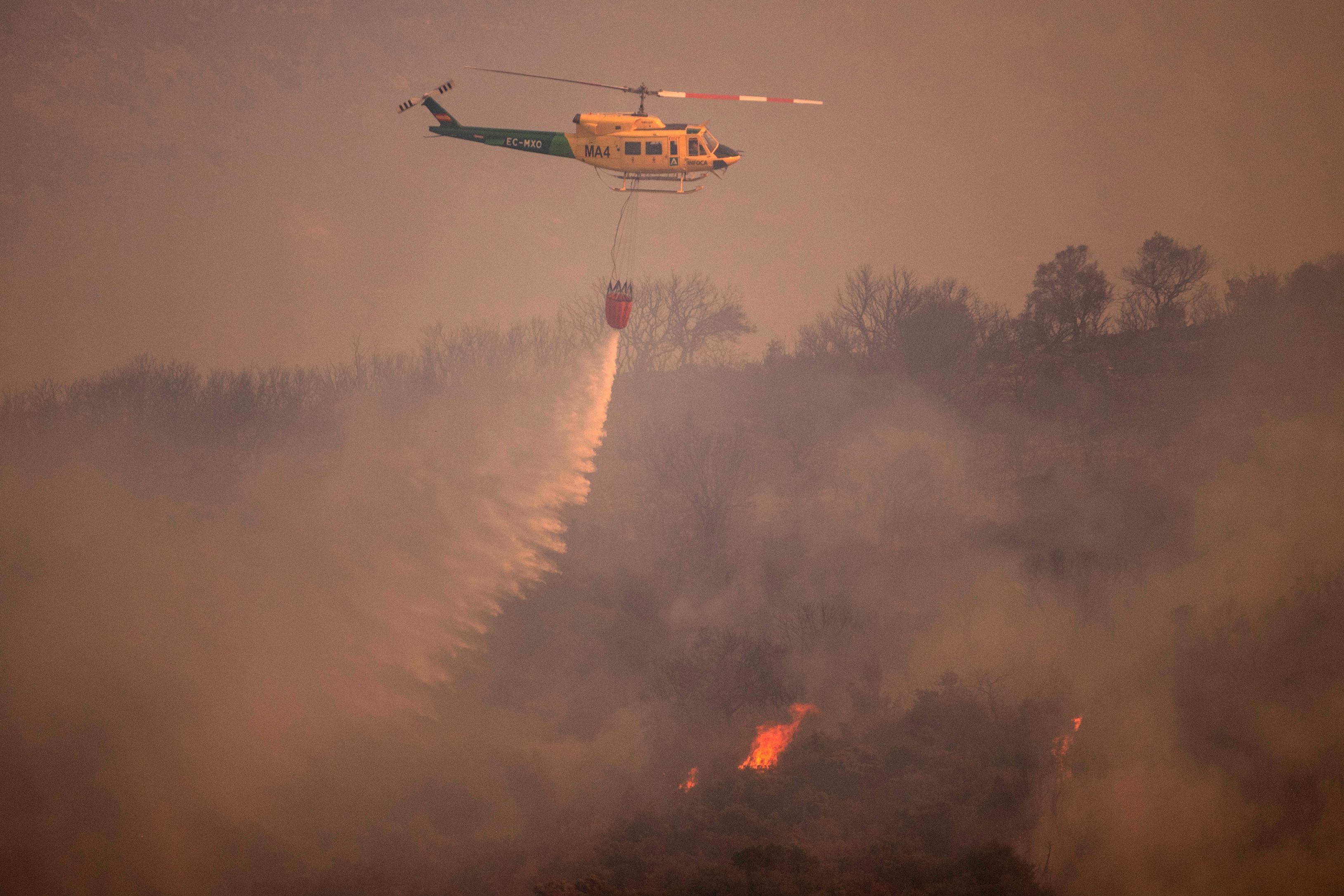 A helicopter is pictured from Alhaurin de la Torre as it drops water over a wildfire in Sierra de Mijas mountain range in Malaga province on July 15.
