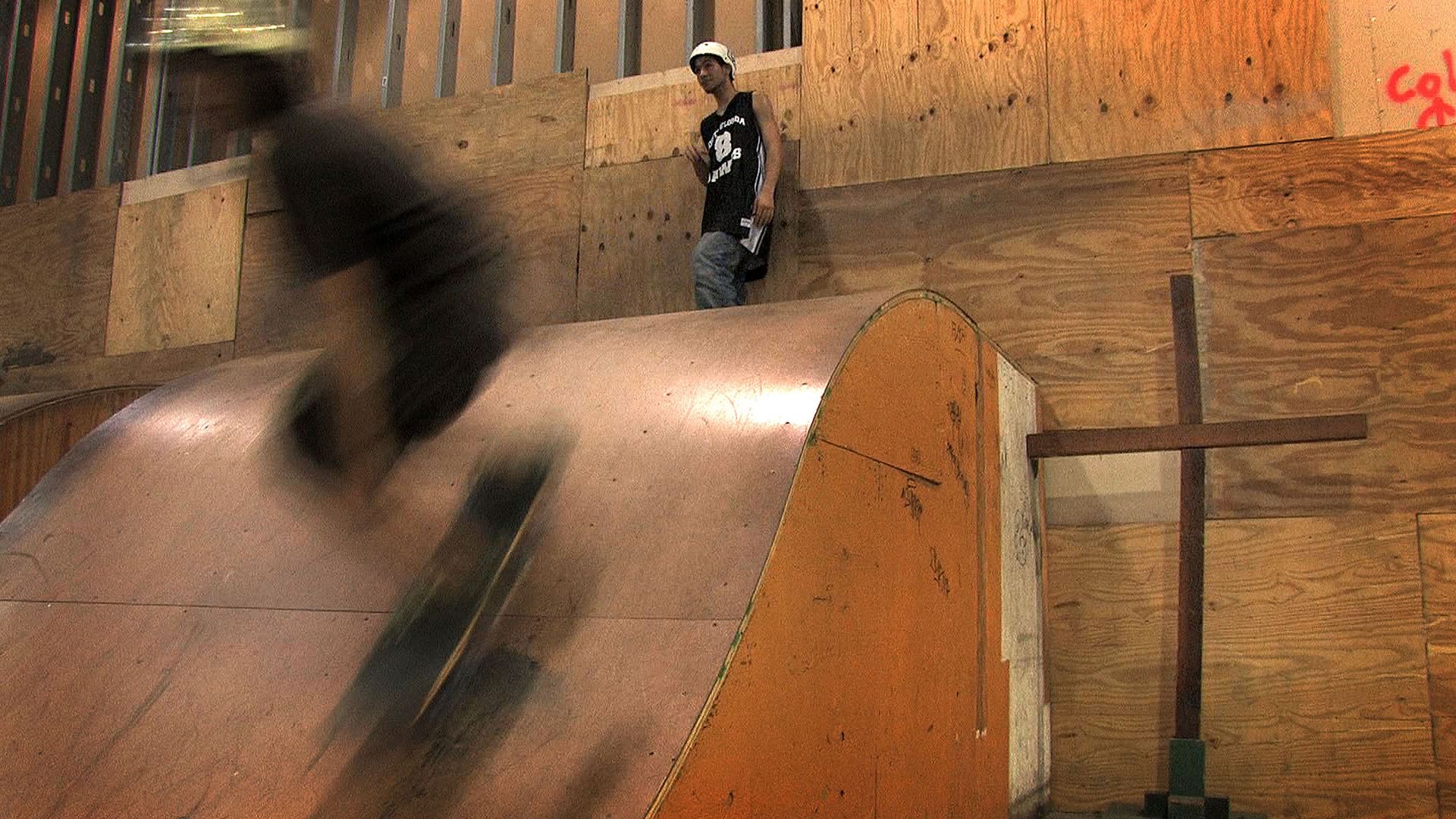 Skaters go down a wooden halfpipe 