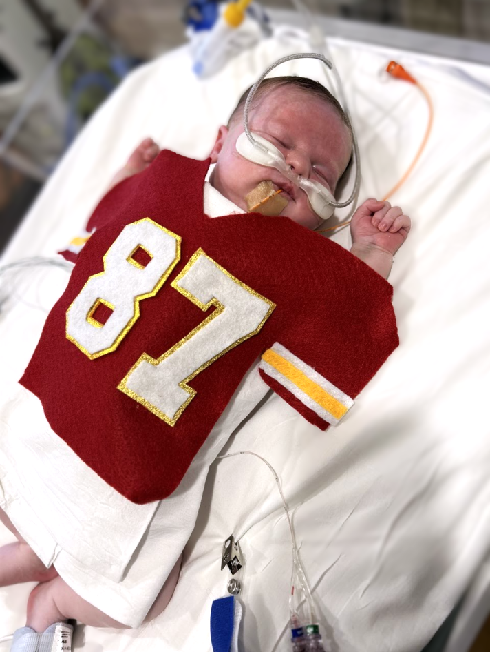 Photo shows a baby dressed at Travis Kelce.