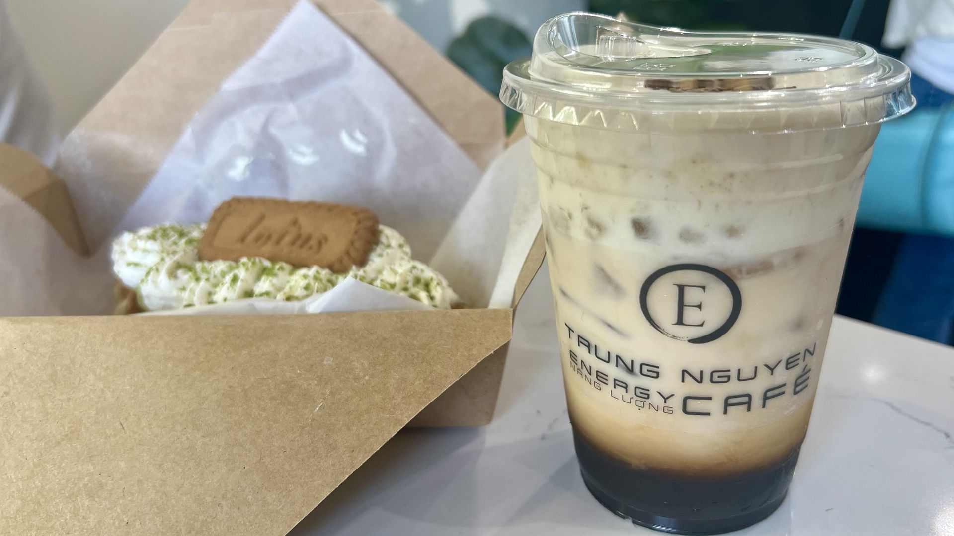 A clear cup of coffee with ice and foam