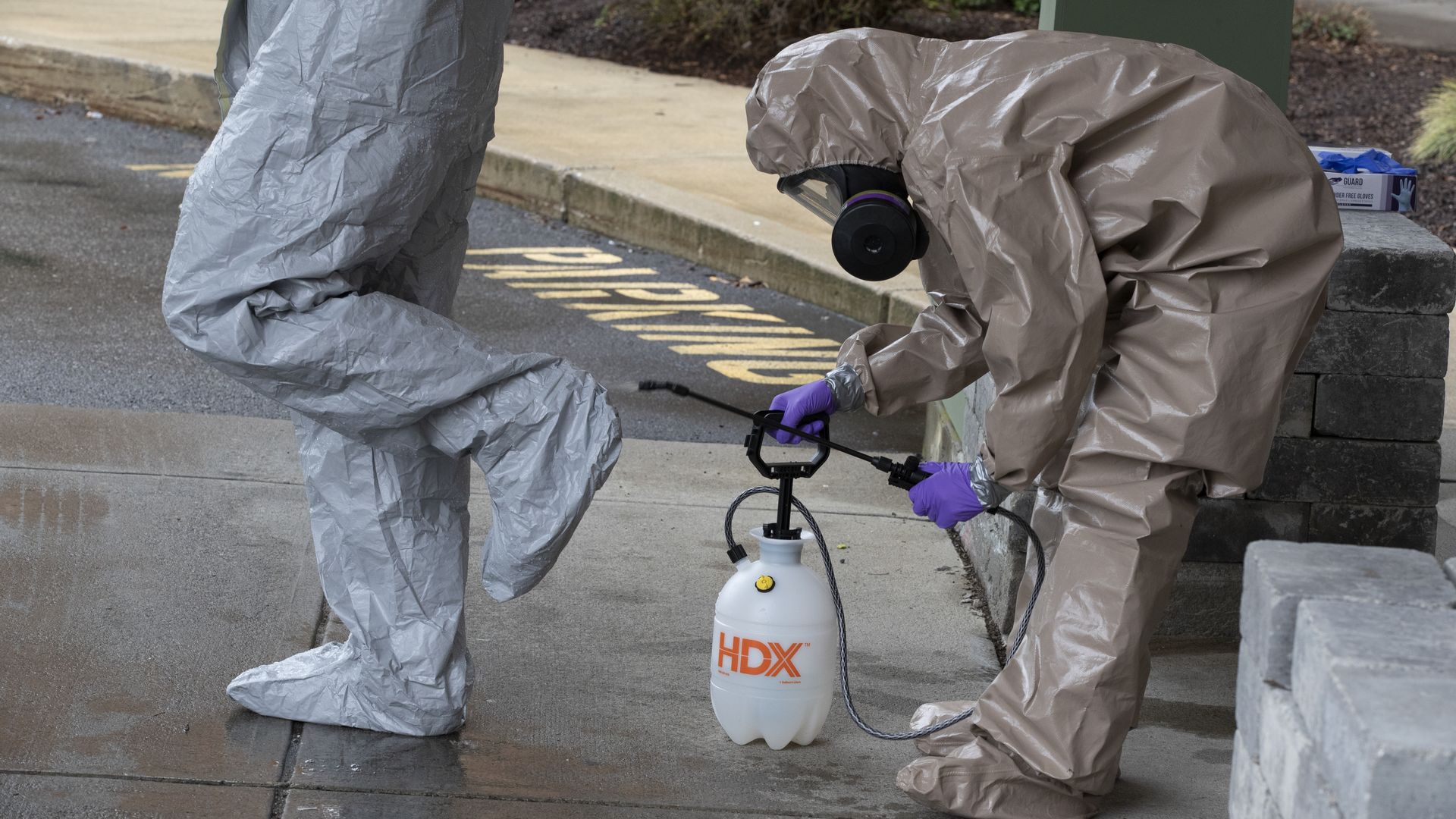Members of the Massachusetts National Guard remove their hazmat suits