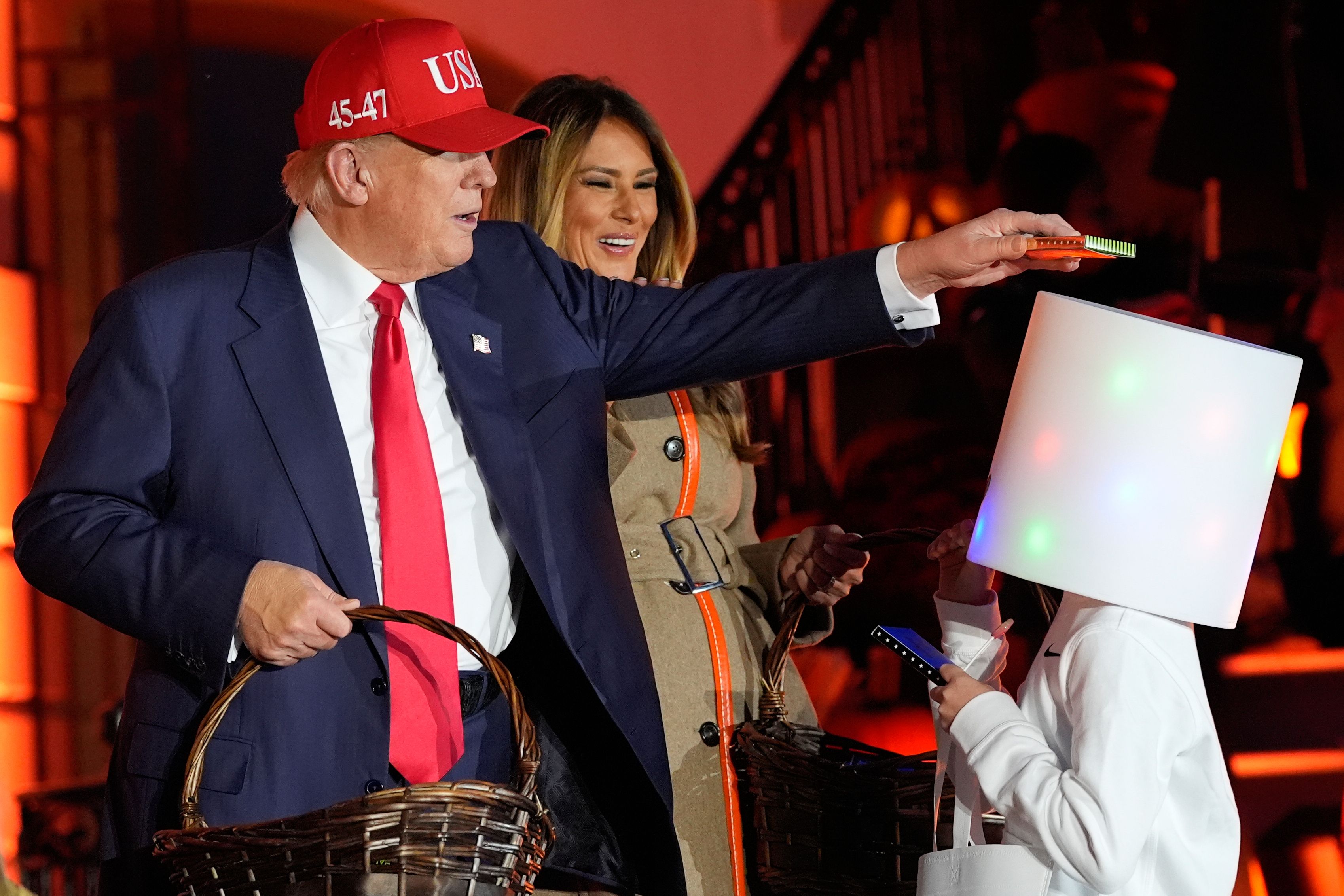 President Trump places a piece of candy on a trick-or-treater's head at the White House yesterday.