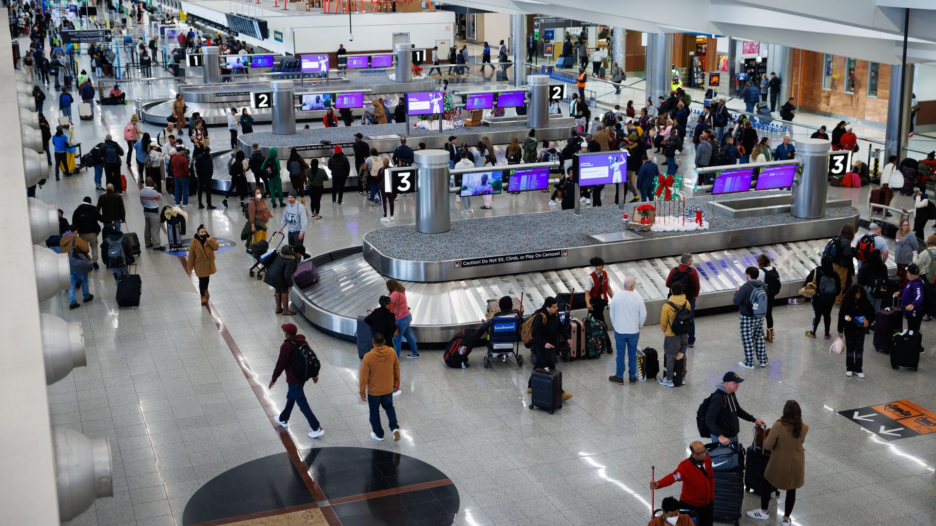 Air travel passengers wait for baggage at luggage carousels in the Atlanta airport