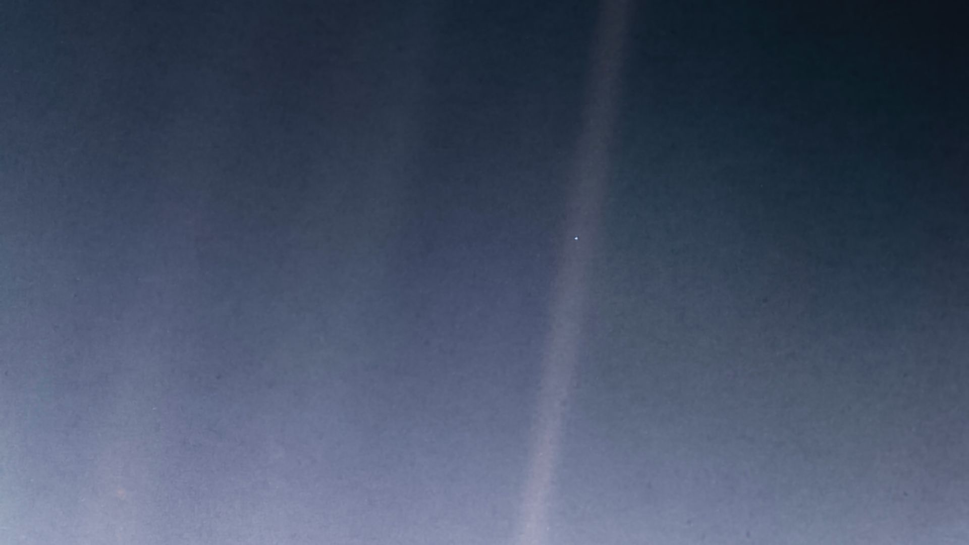 A speck of light suspended in a beam of sunlight. That speck of light is Earth seen from 4 billion miles away.