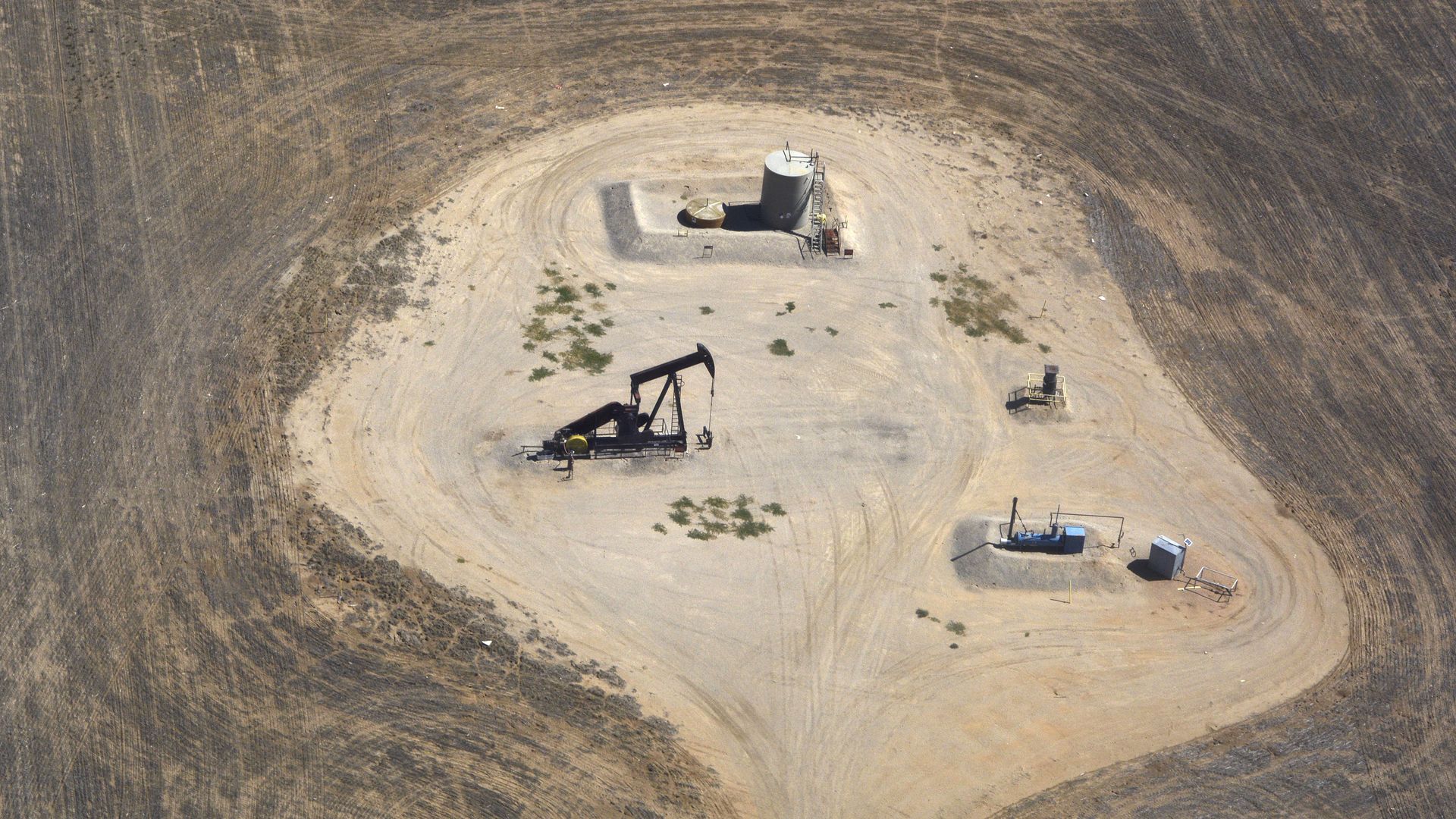 A pumpjack surrounded by mostly empty land as seen from a plane arriving at Denver International Airport.