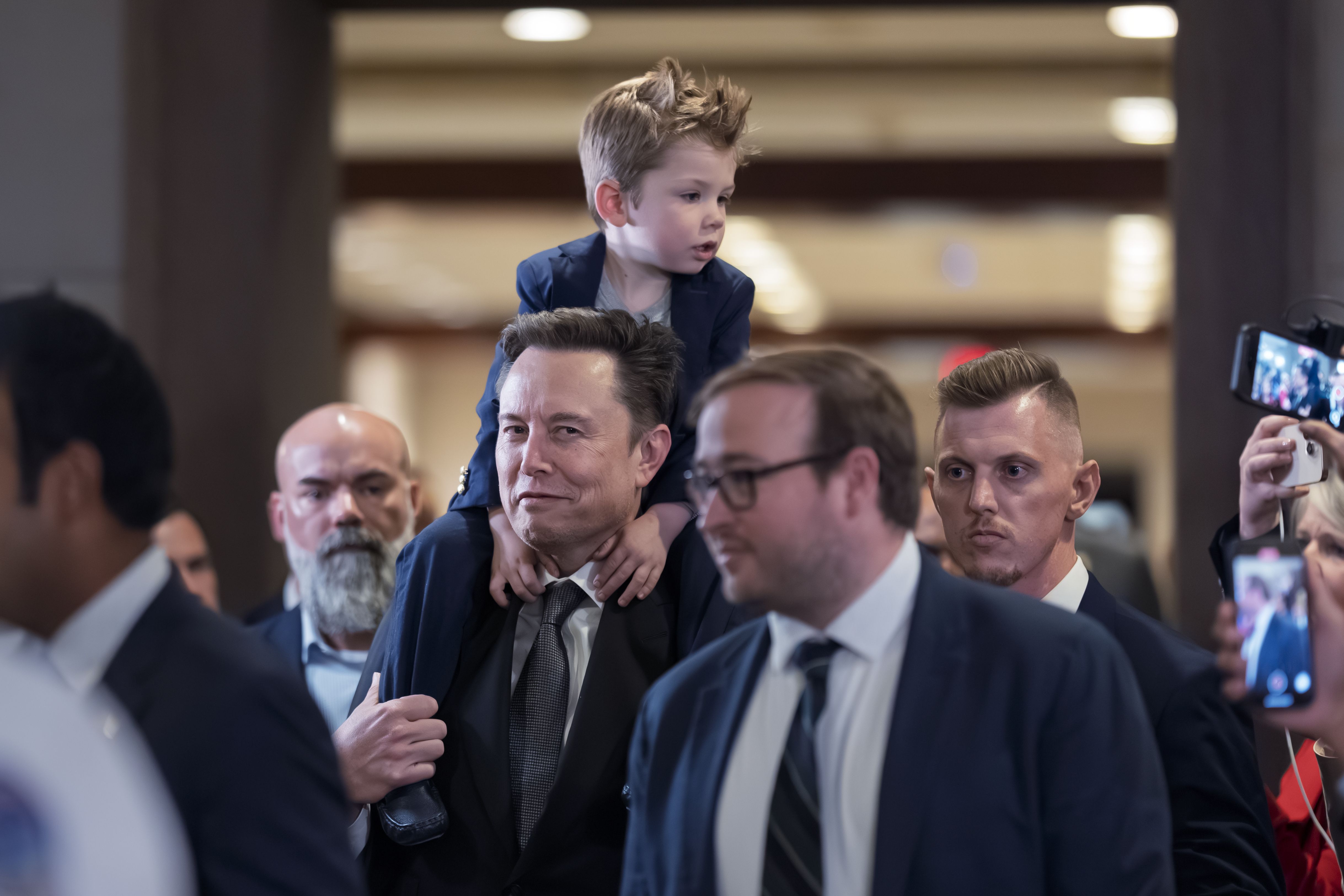 Elon Musk carries his son X ร A-Xii after a meeting on Capitol Hill yesterday.