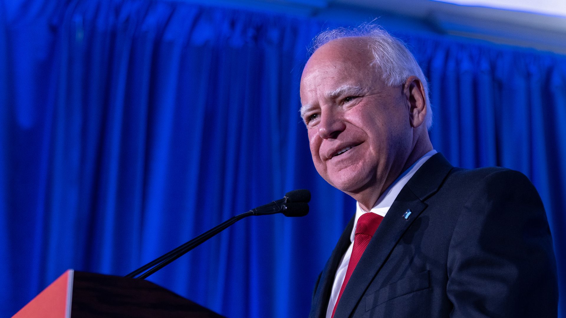 Tim Walz speaks at a lectern 
