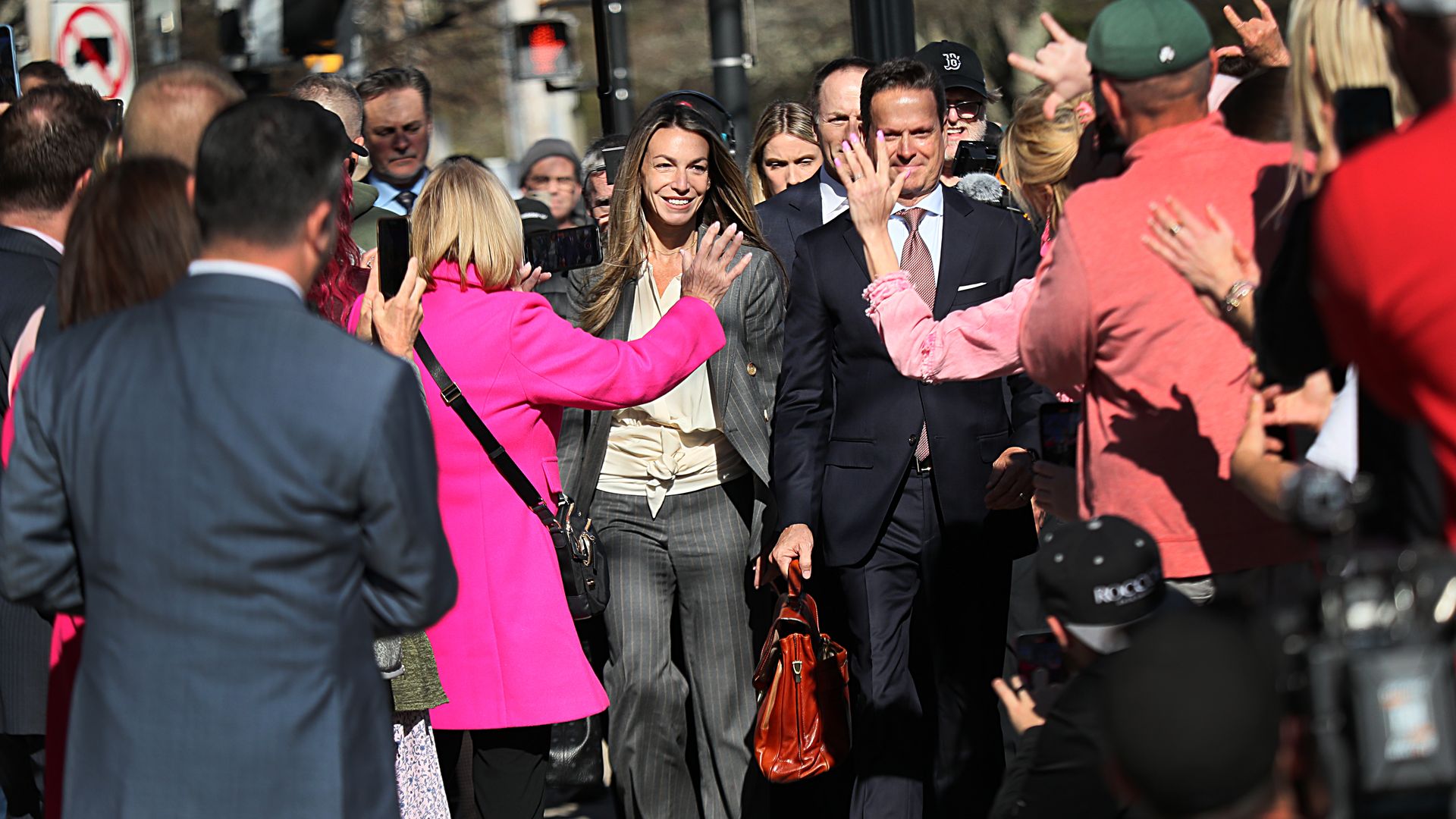 A man and woman walk through a crowd of people