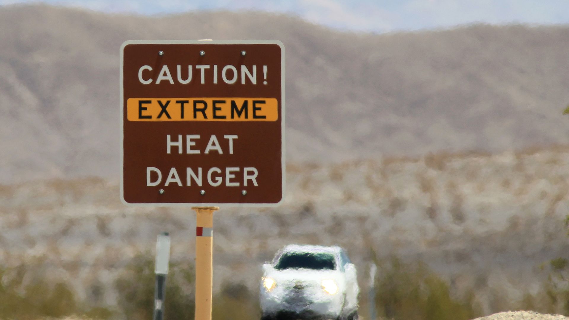 Heat waves rise near a heat danger warning sign in Death Valley National Park, California. 