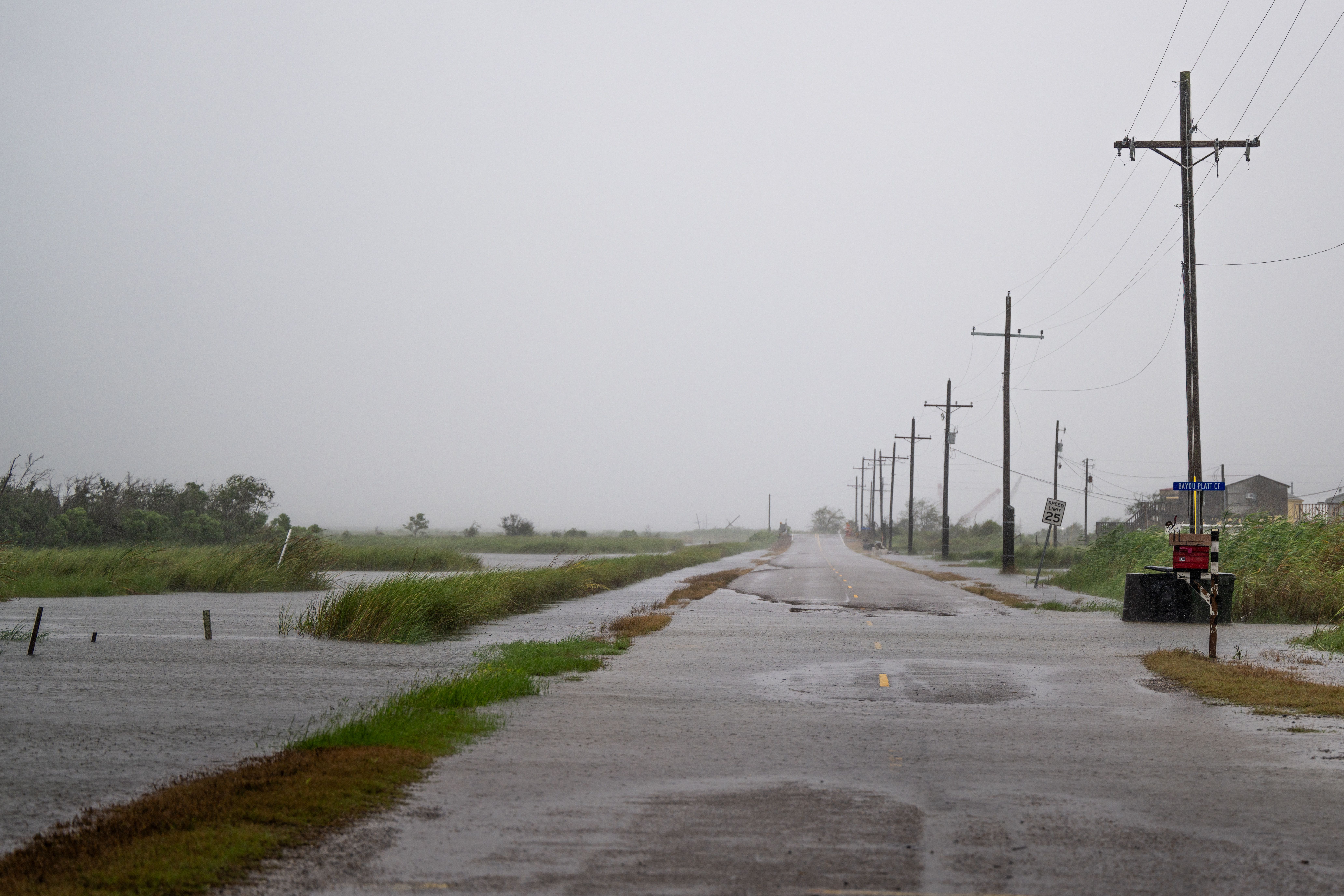 Floodwater creeps across an empty roadway.