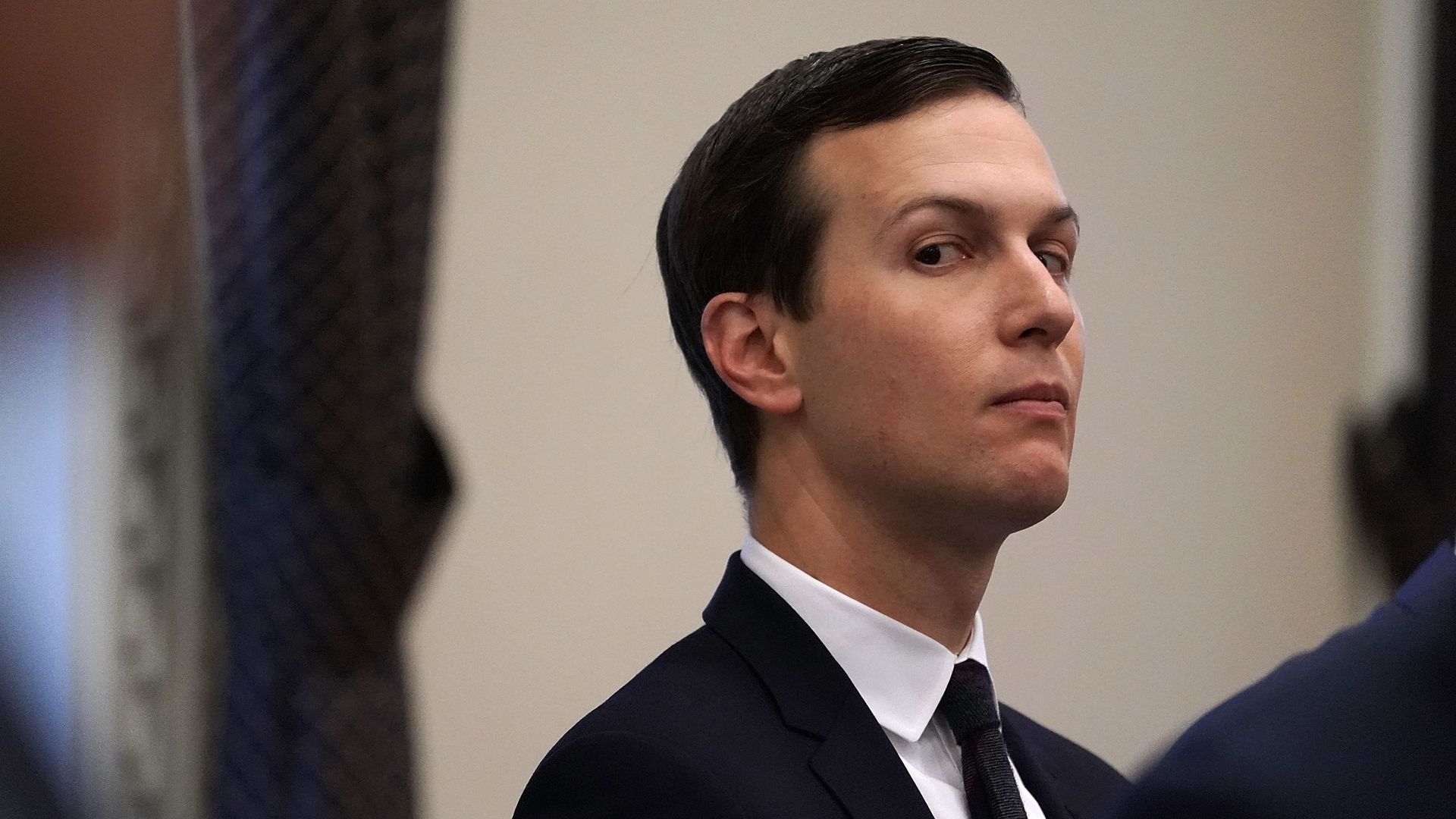 Jared Kushner looks out of the corner of his eye with his head tilted up
