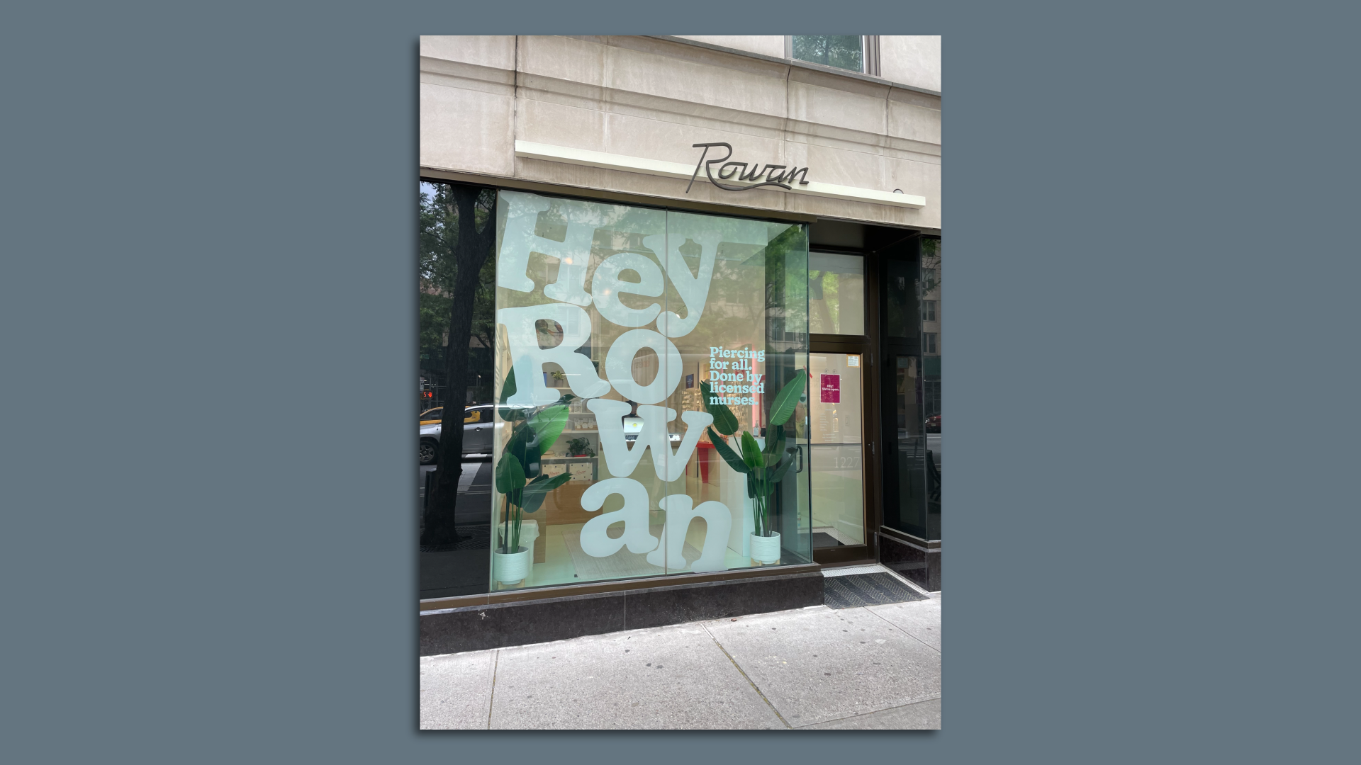 A glass storefront window in front of an urban sidewalk