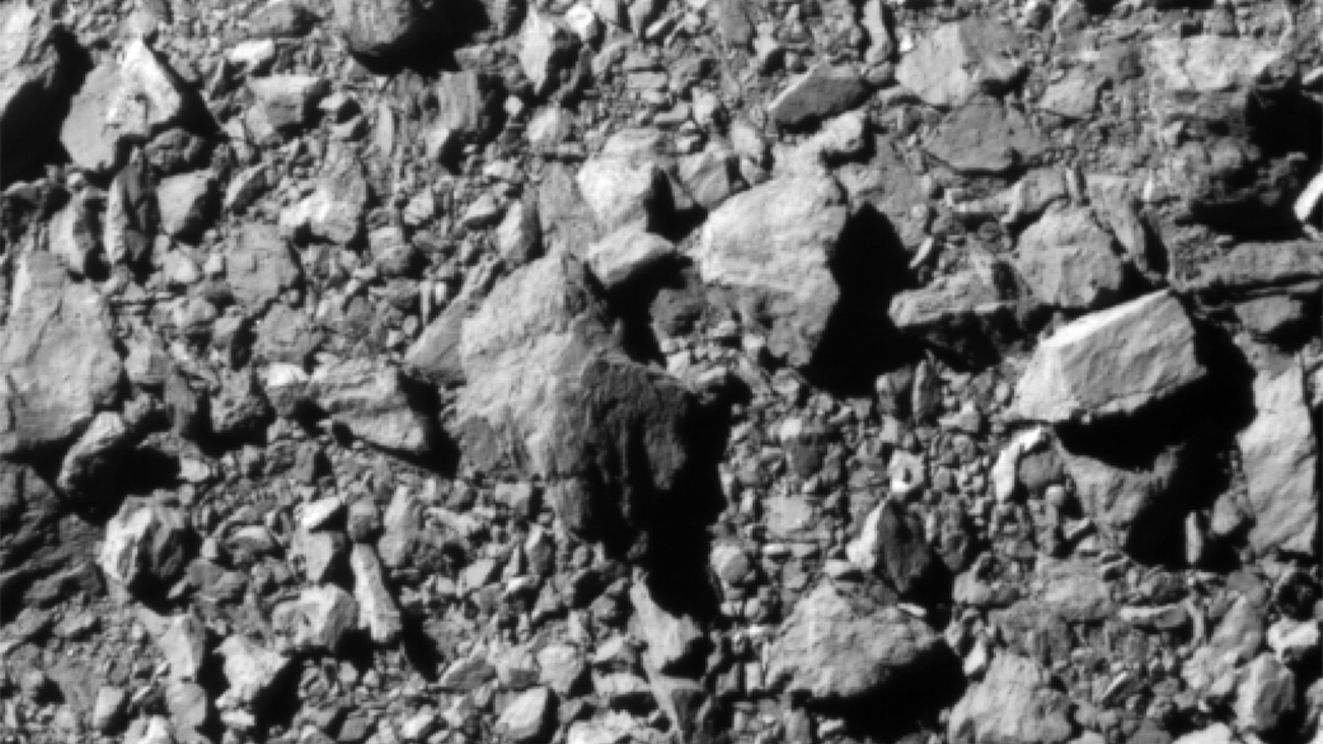 A smattering of rocks on an asteroid as the DART spacecraft closes in on its target