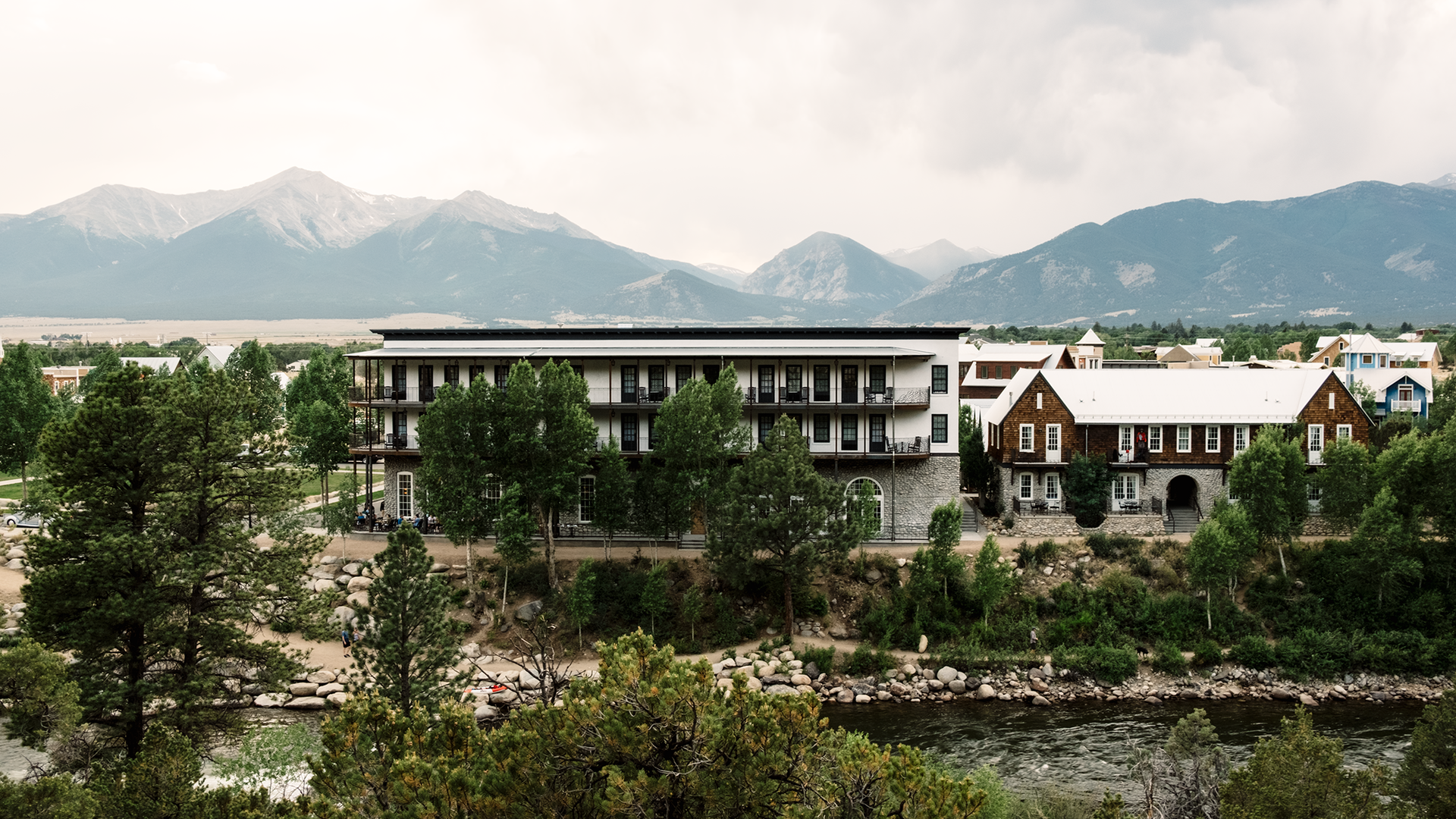 view of the mountains with buildings and river in the foreground