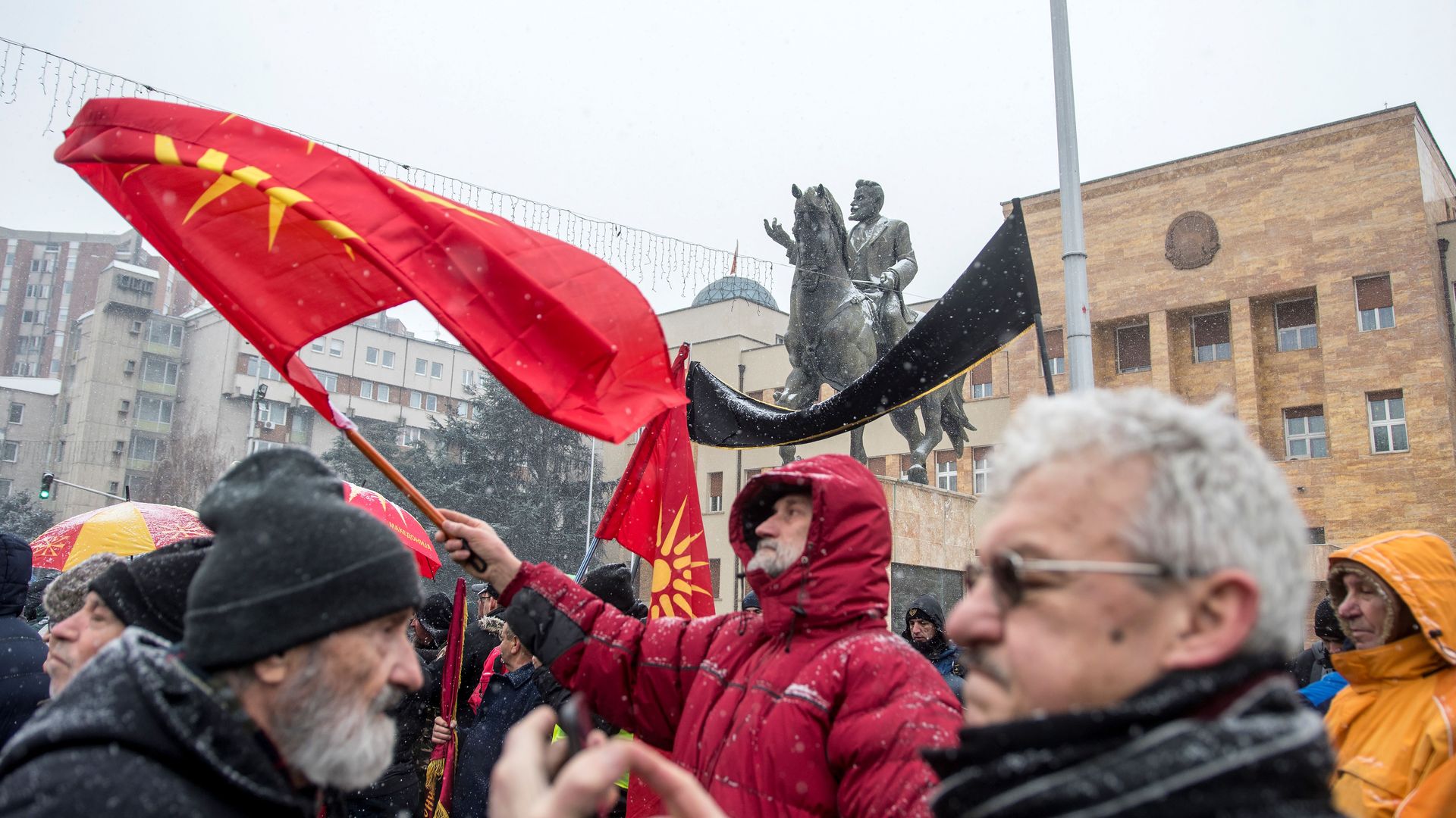 A demonstrator waves the old Macedonian flag during a protest against a process of renaming the country's name in front of the Parliament building.