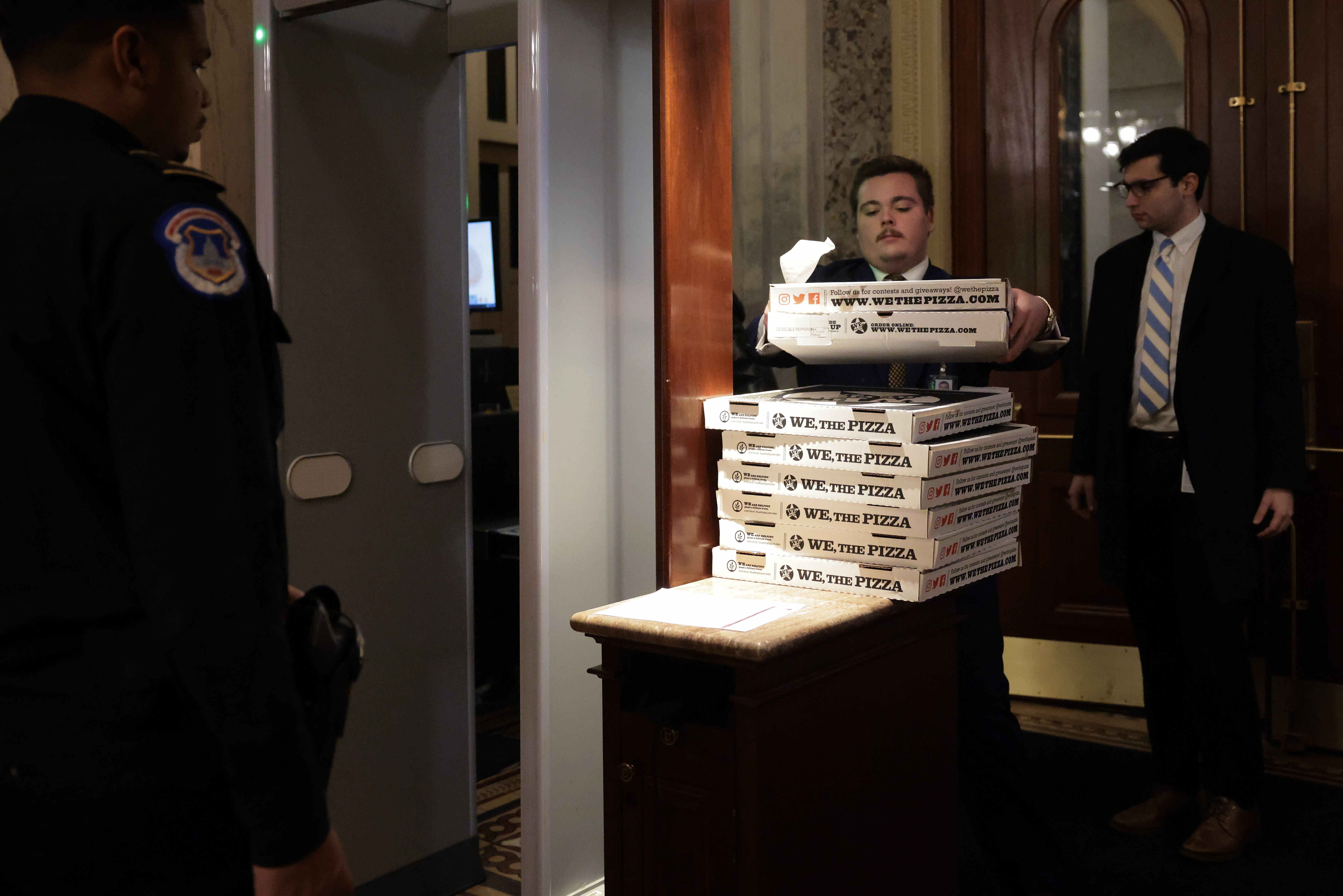 Workers bring boxes of pizza into the U.S. Capitol ahead of a Senate "vote-a-rama" on February 20, 2025 in Washington, DC. The Senate is set to host an all-night marathon vote, referred to as a "vote-a-rama", as Republicans look to pass their GOP budget resolution. (Photo by Kayla Bartkowski/Getty I