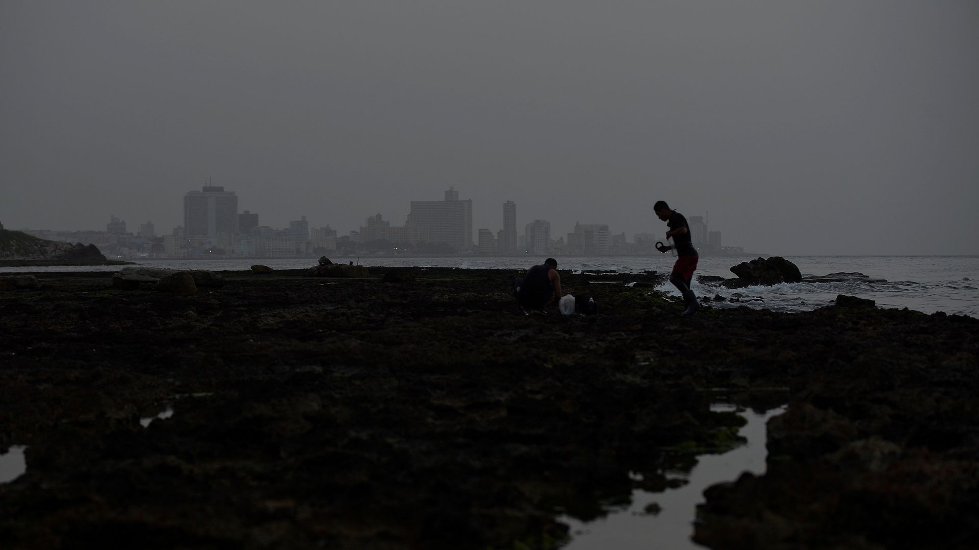  Fishermen are seen near the sea as a vast cloud of Sahara dust is blanketing the city of Havana on June 24