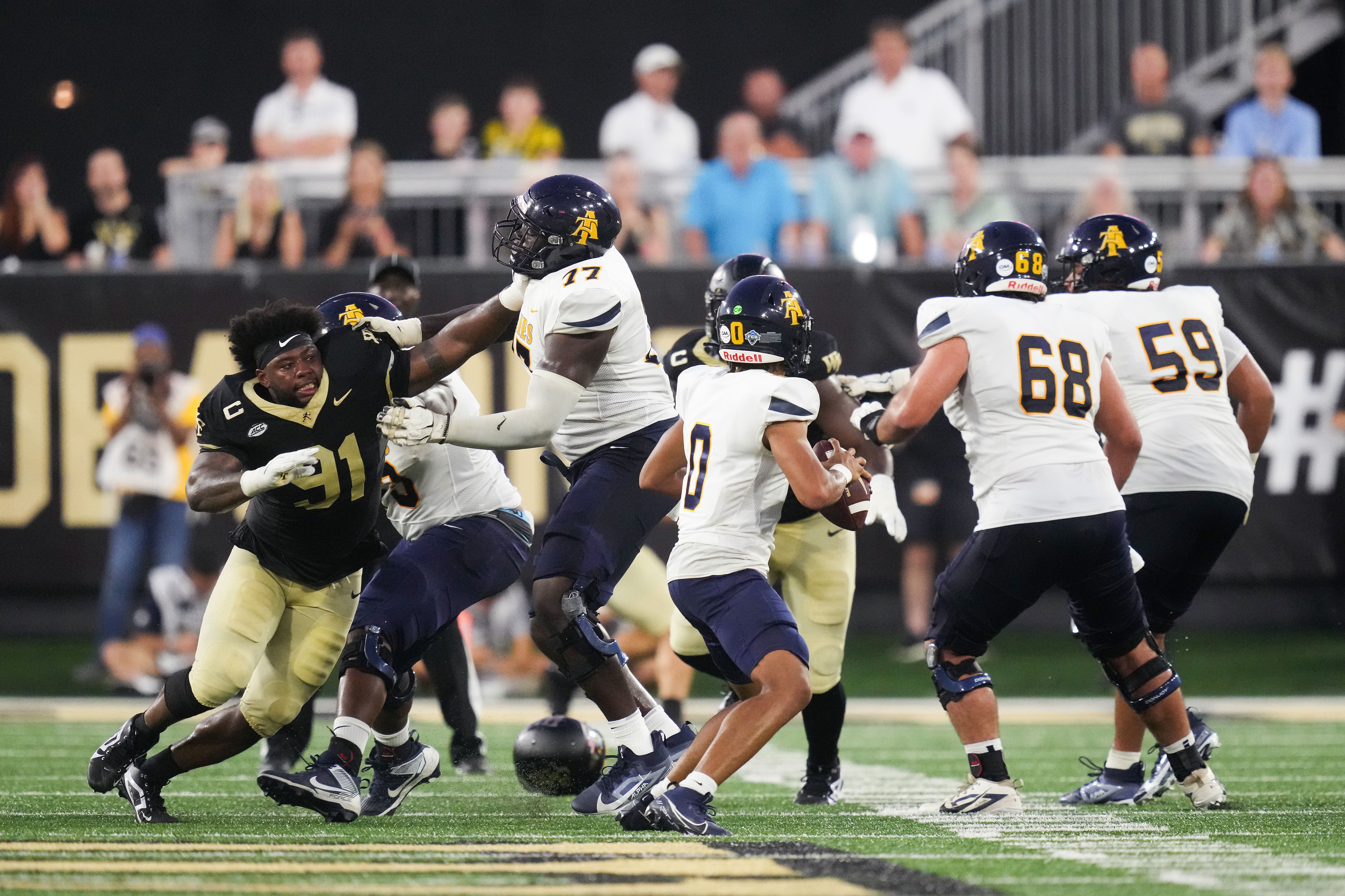 Kevin Pointer #91 of the Wake Forest Demon Deacons loses his helmet as he rushes against Jason Ivey #77 of the North Carolina A&T Aggies during the first half of their game at Truist Field on August 29, 2024 in Winston-Salem, North Carolina. (Photo by Grant Halverson/Getty Images)