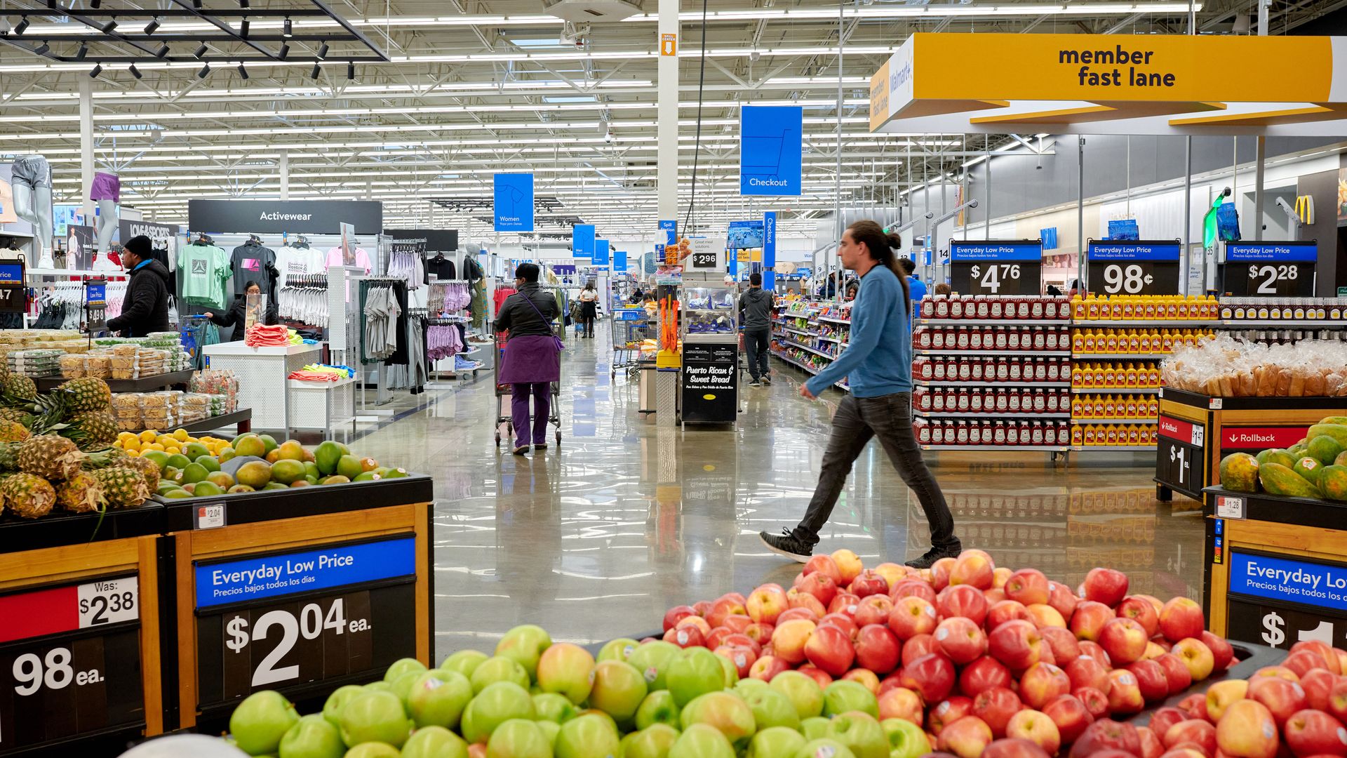 Shoppers walking down aisle of a walmart store