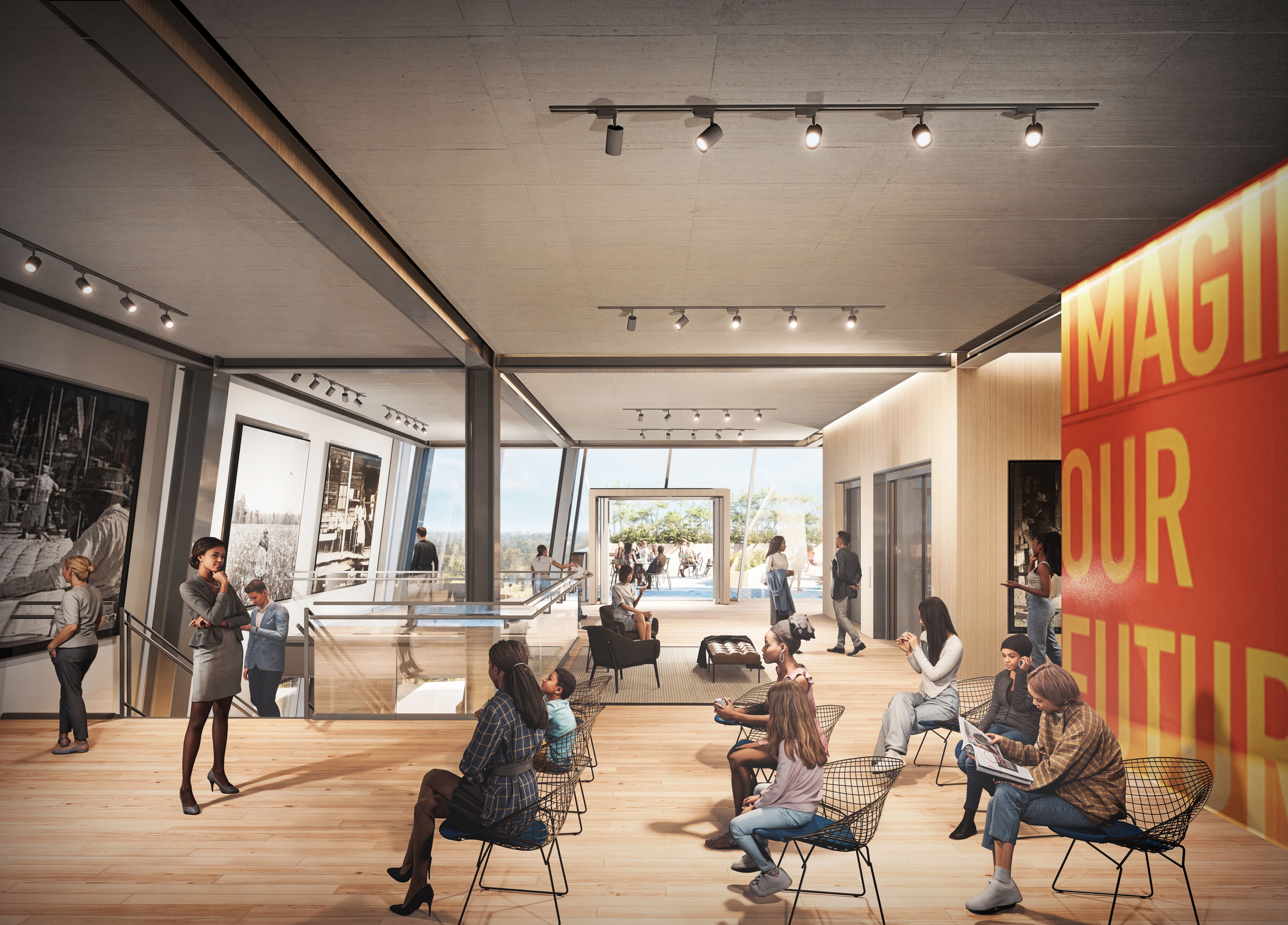 A modern gallery with large black-and-white photos on walls, wooden floor, ceiling lights, and people sitting or standing. A large red and yellow sign reads "IMAGINE OUR FUTURE."