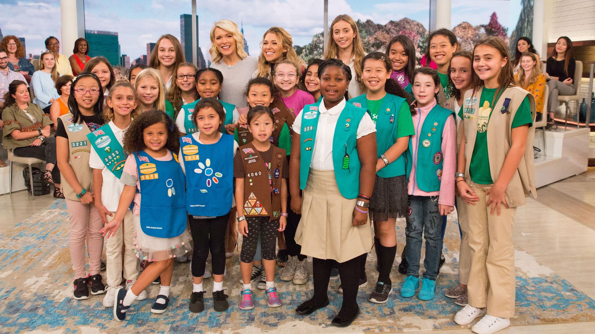 a group of young girls in Girl Scouts uniforms posing for a photo with journalist Megyn Kelly