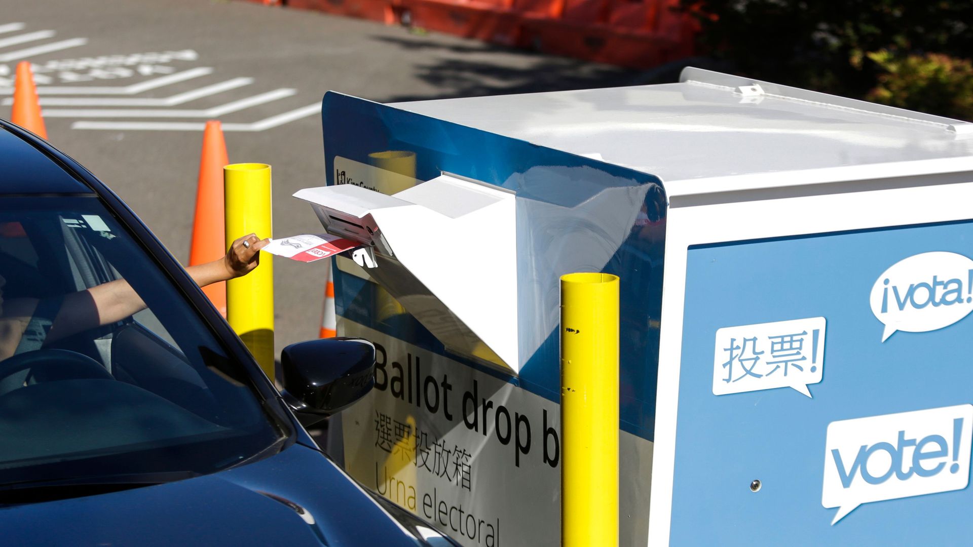 A voter inserts a ballot in a drive-up drop box for the August 4 Washington state primary at King County Elections in Renton, Washington on August 3, 2020. 