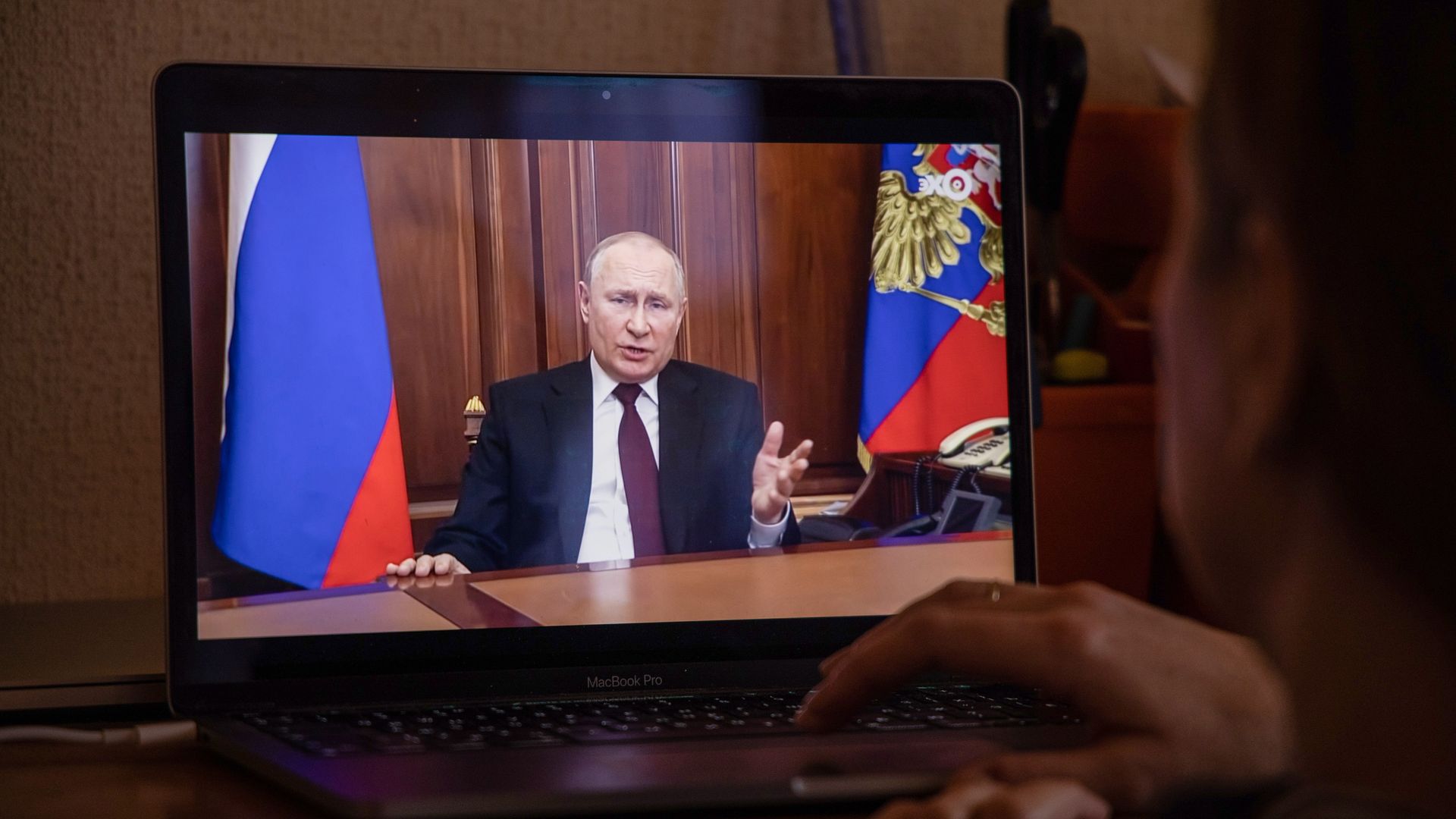 A person in Moscow watching a speech Russian President Vladimir Putin on a computer in February 2022.