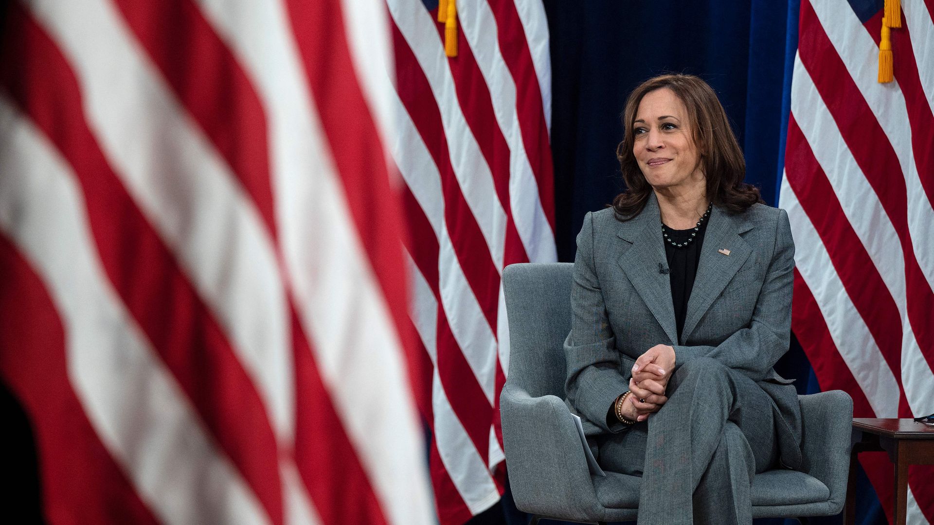 Vice President Kamala Harris is seen sitting amid a spray of U.S. flags.