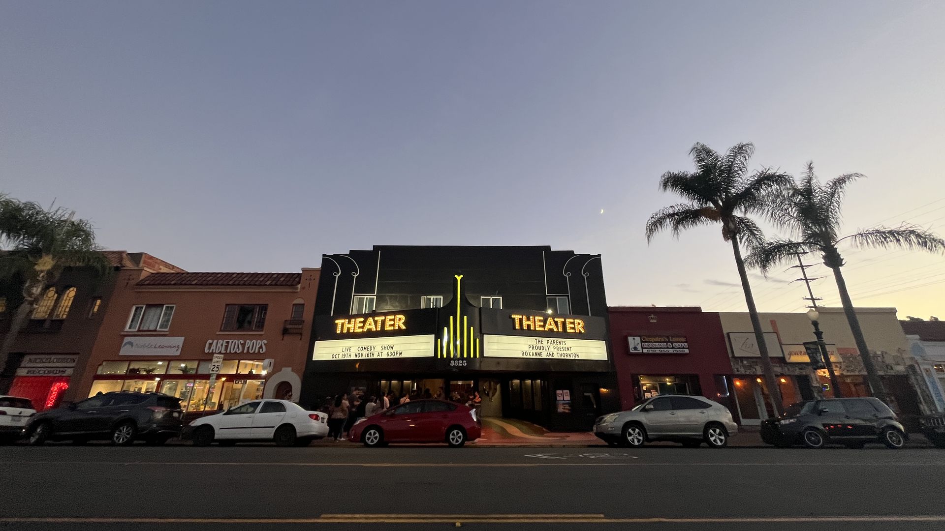 The entrance of a theater at dusk.