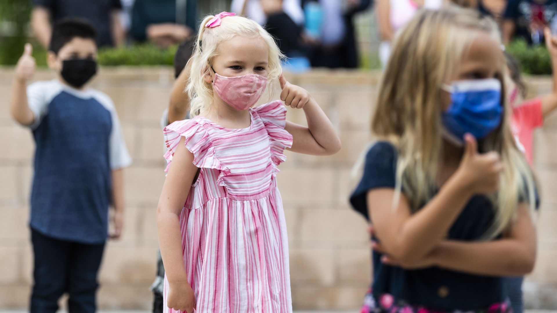 A kindergarten student gives the thumbs up to her teacher before starting the first day of kindergarten at Laguna Niguel Elementary School in Laguna Niguel, CA.
