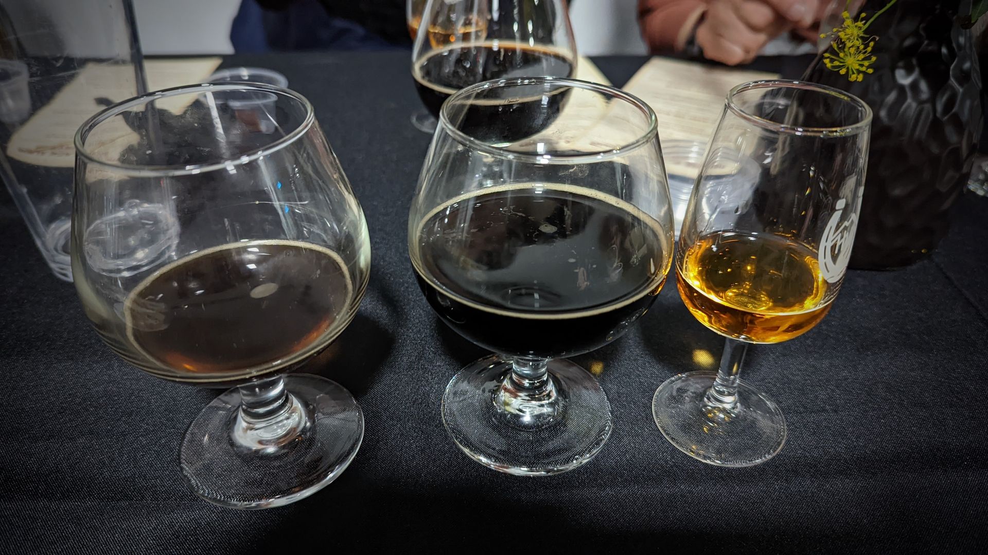 Barrel-aged Black Album, center, flanked by the original Black Album and High West Bourye at Level Crossing Brewery. Photo: Erin Alberty/Axios 