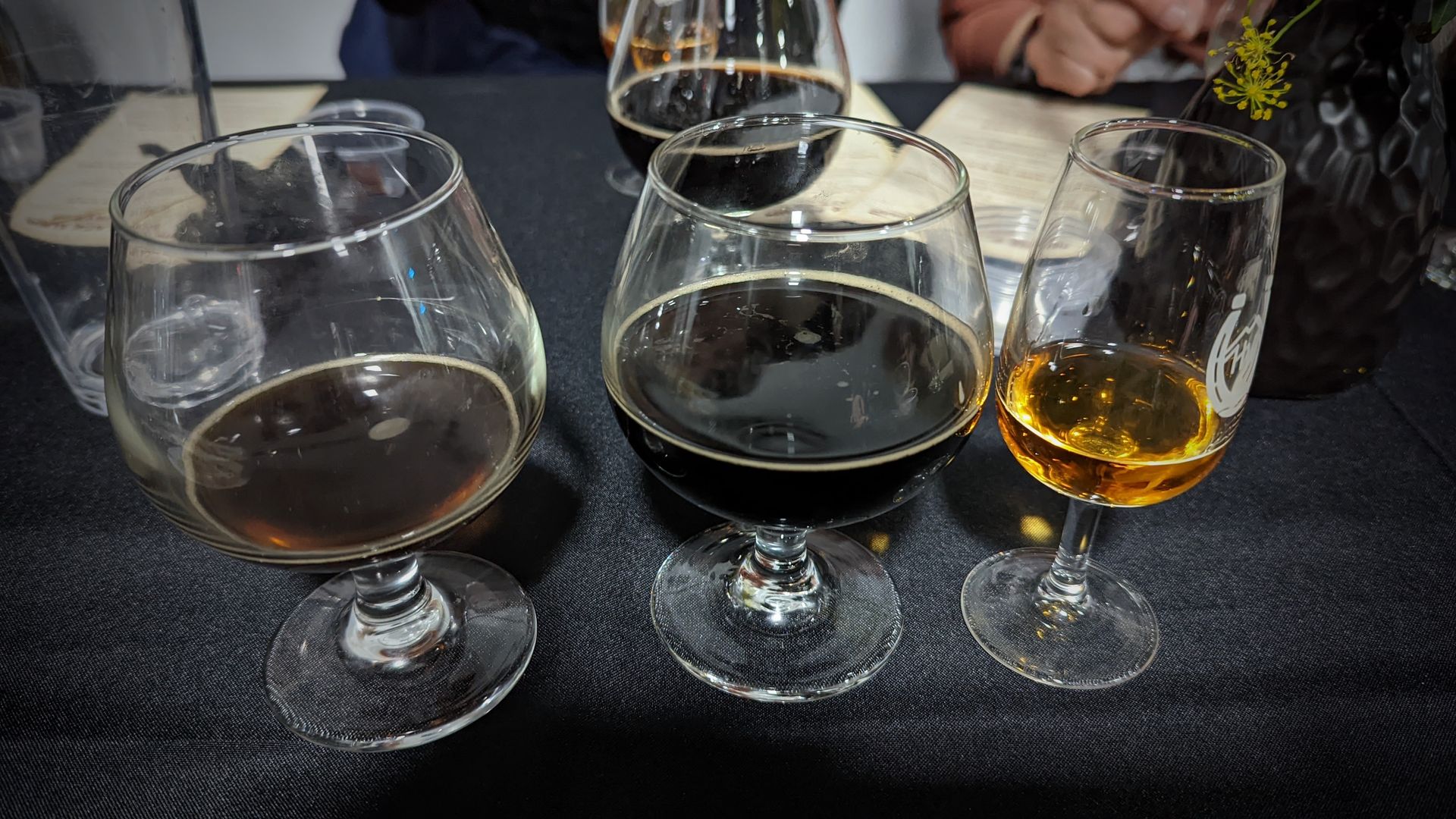 Barrel-aged Black Album, center, flanked by the original Black Album and High West Bourye at Level Crossing Brewery. Photo: Erin Alberty/Axios