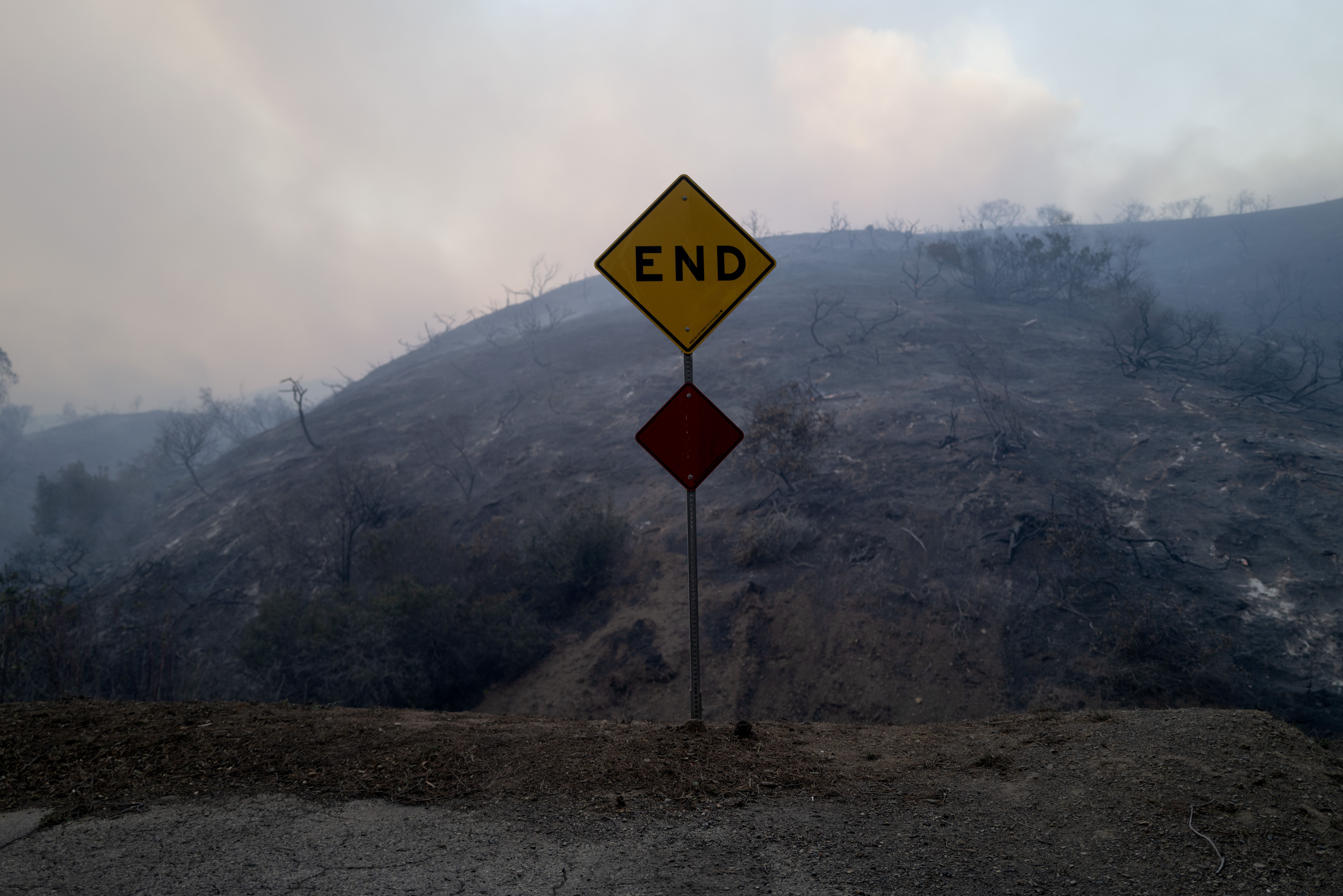 A sign that reads "END" with burnt hills in the background. 