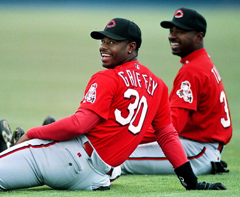 Ken Griffey Jr. and Michael Tucker smile on the field before a spring training game.