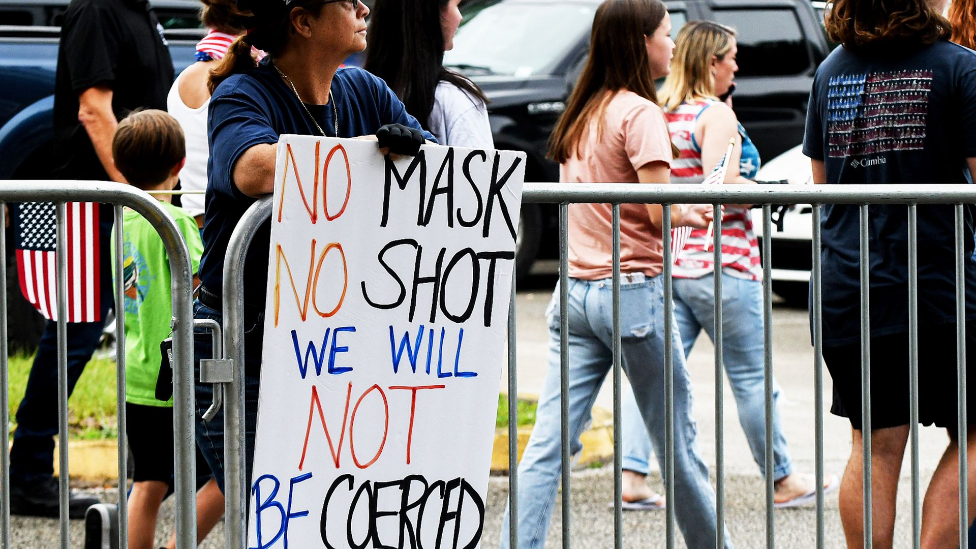 A woman holds an anti-mask placard outside a meeting of the Volusia County School Board in Deland, Florida