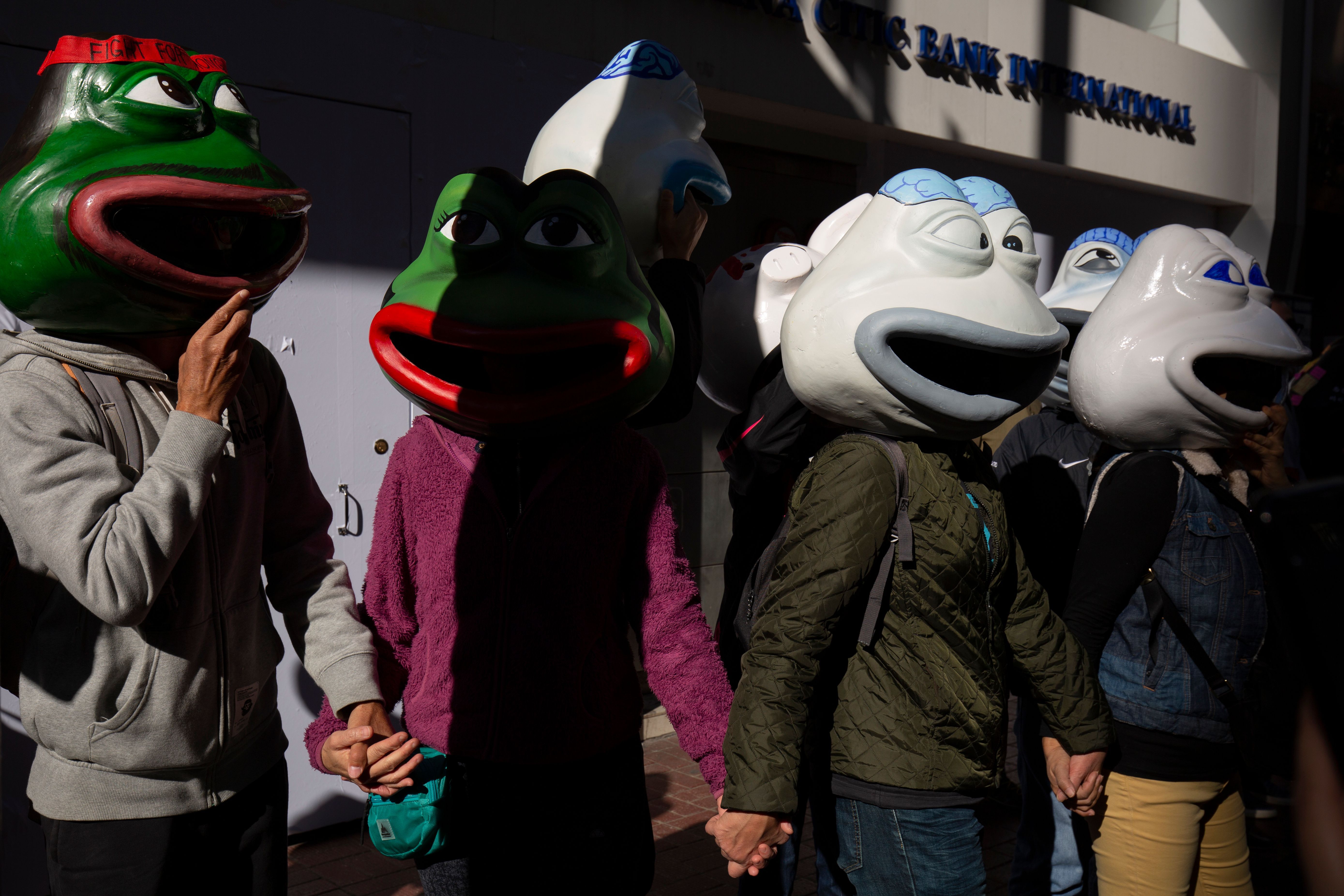 Protestors wearing frog masks