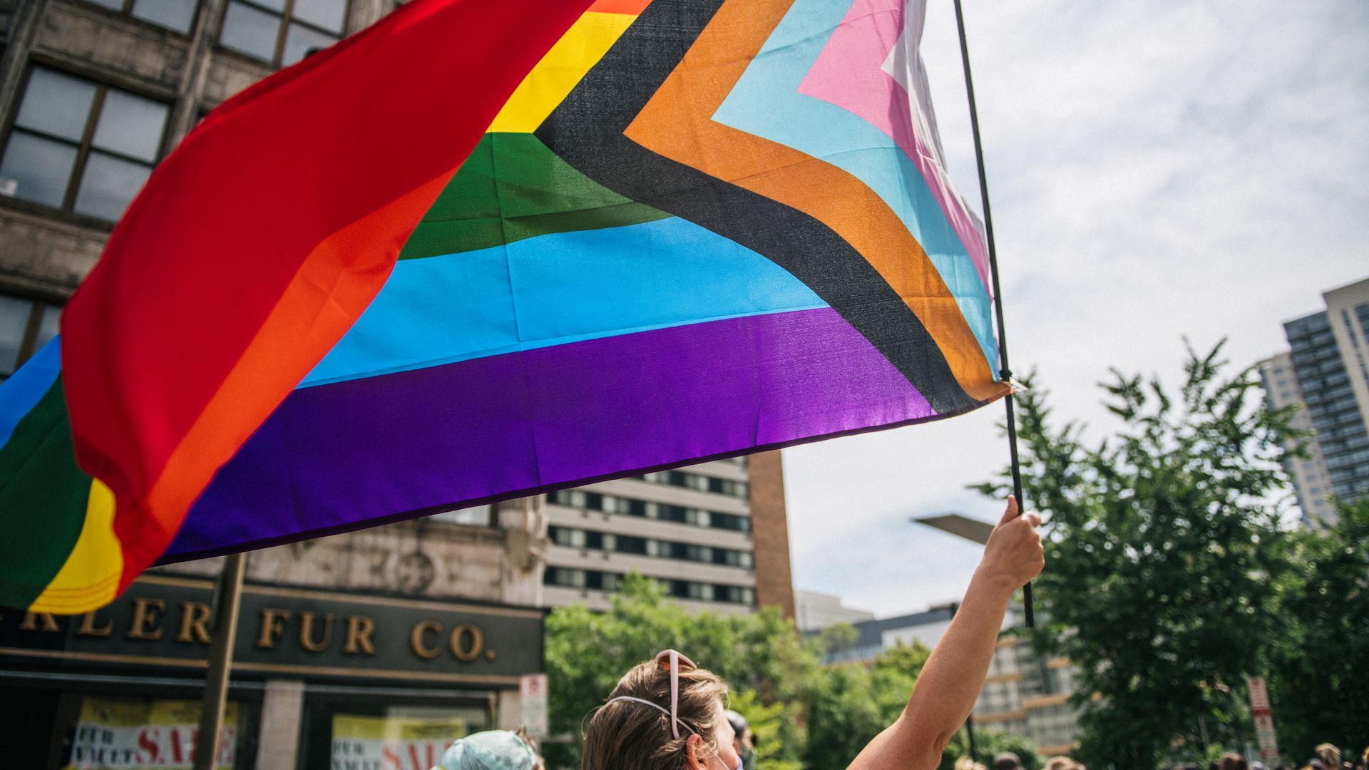 A woman waves a pride flag in downtown Minneapolis.