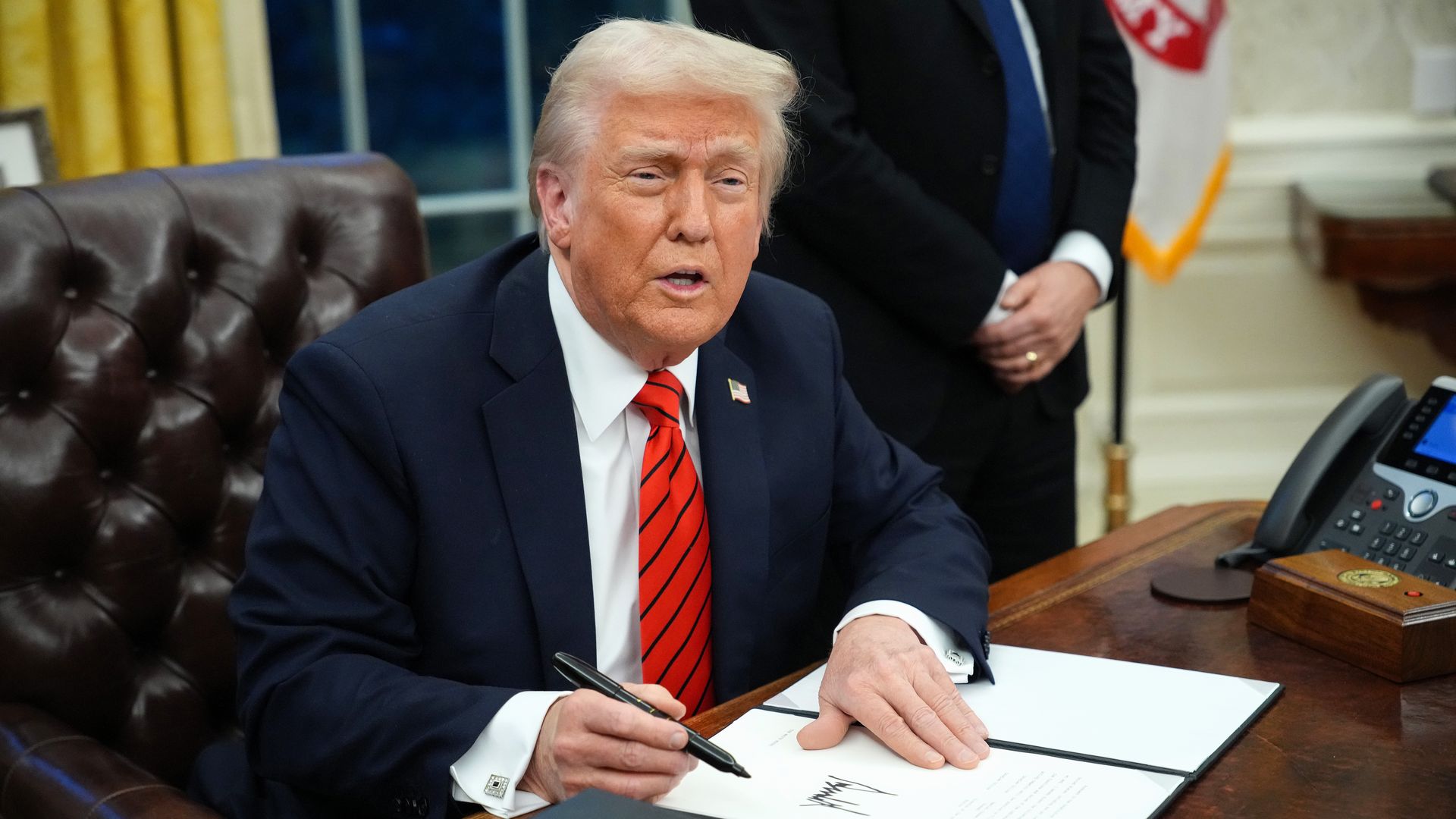 Donald Trump photographed signing executive orders in the Oval Office