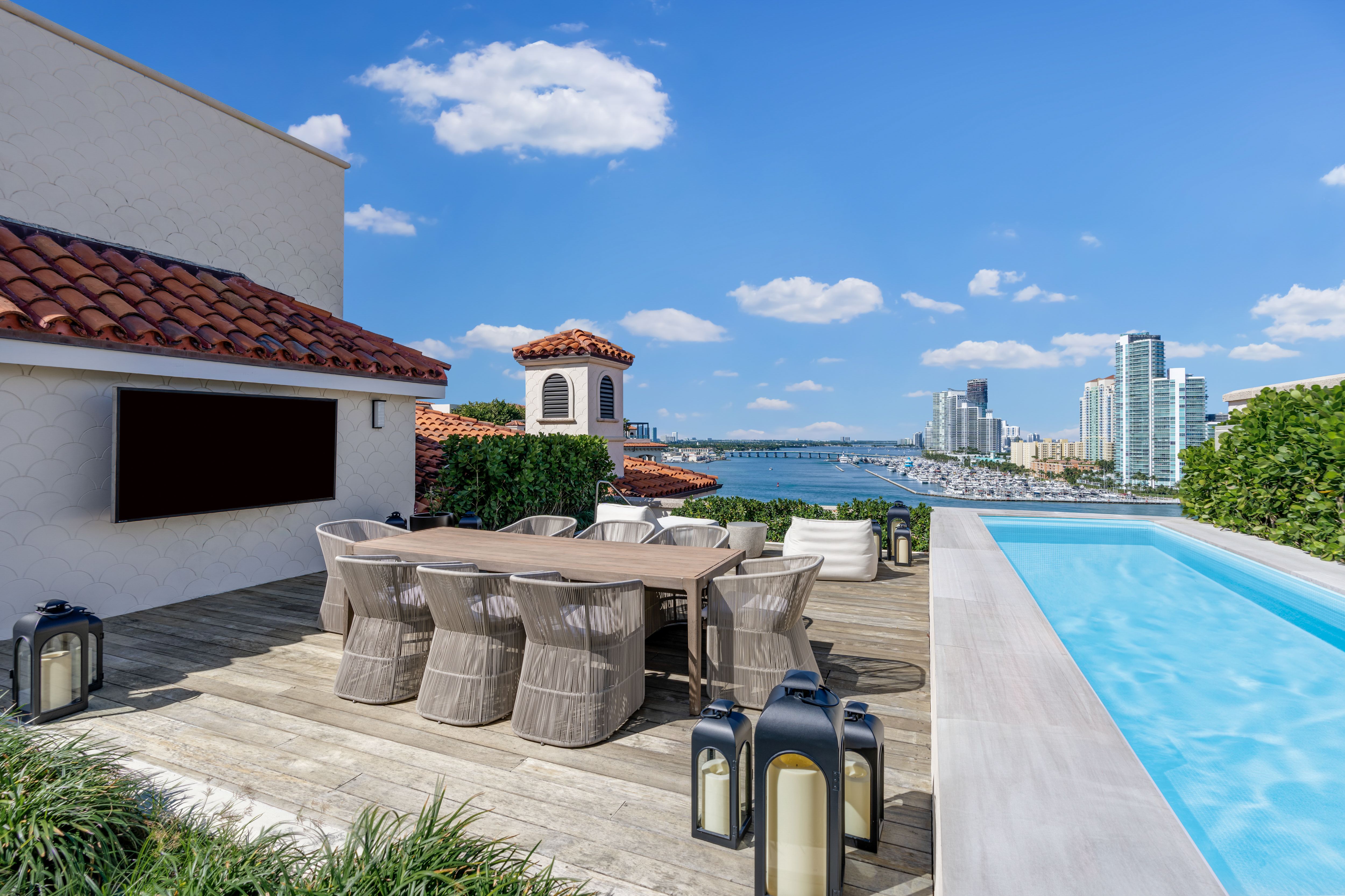 A rooftop pool and dining area at a Fisher Island condo.