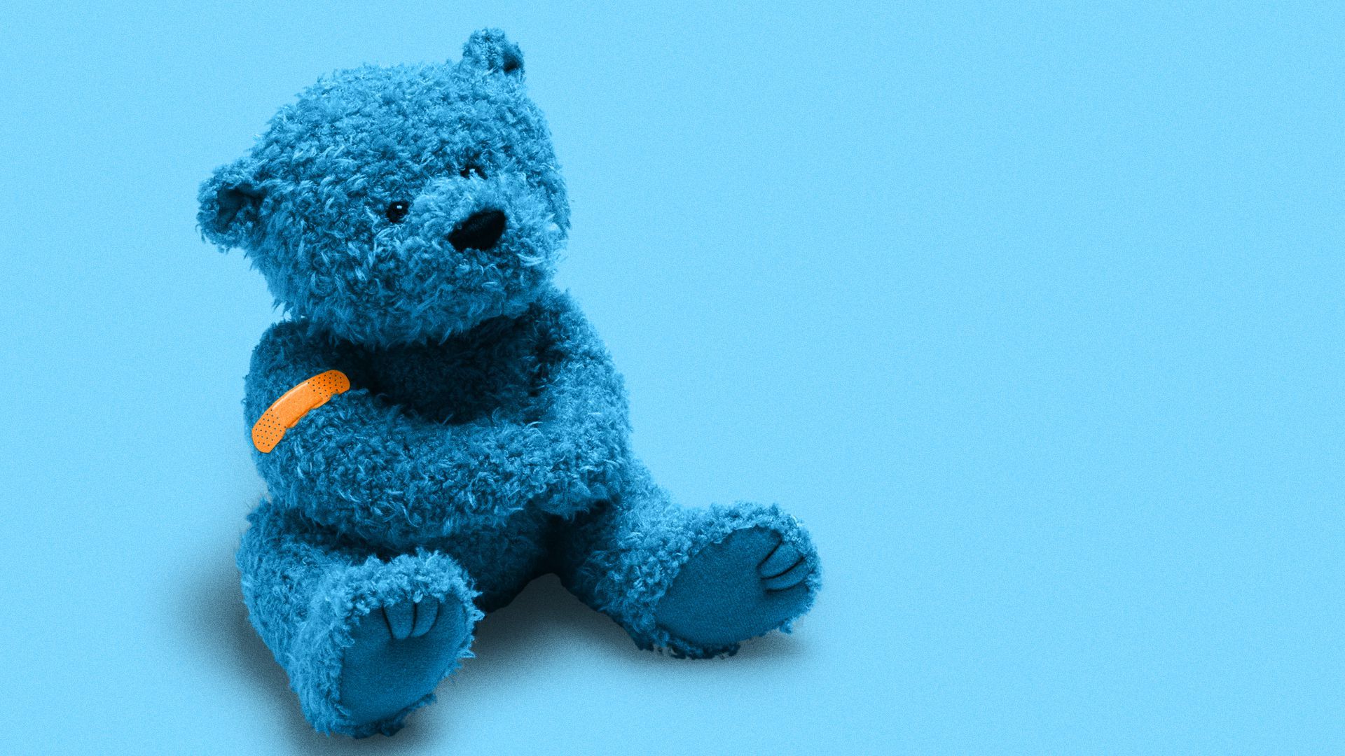 Blue teddy bear with orange band-aid on its arm. 