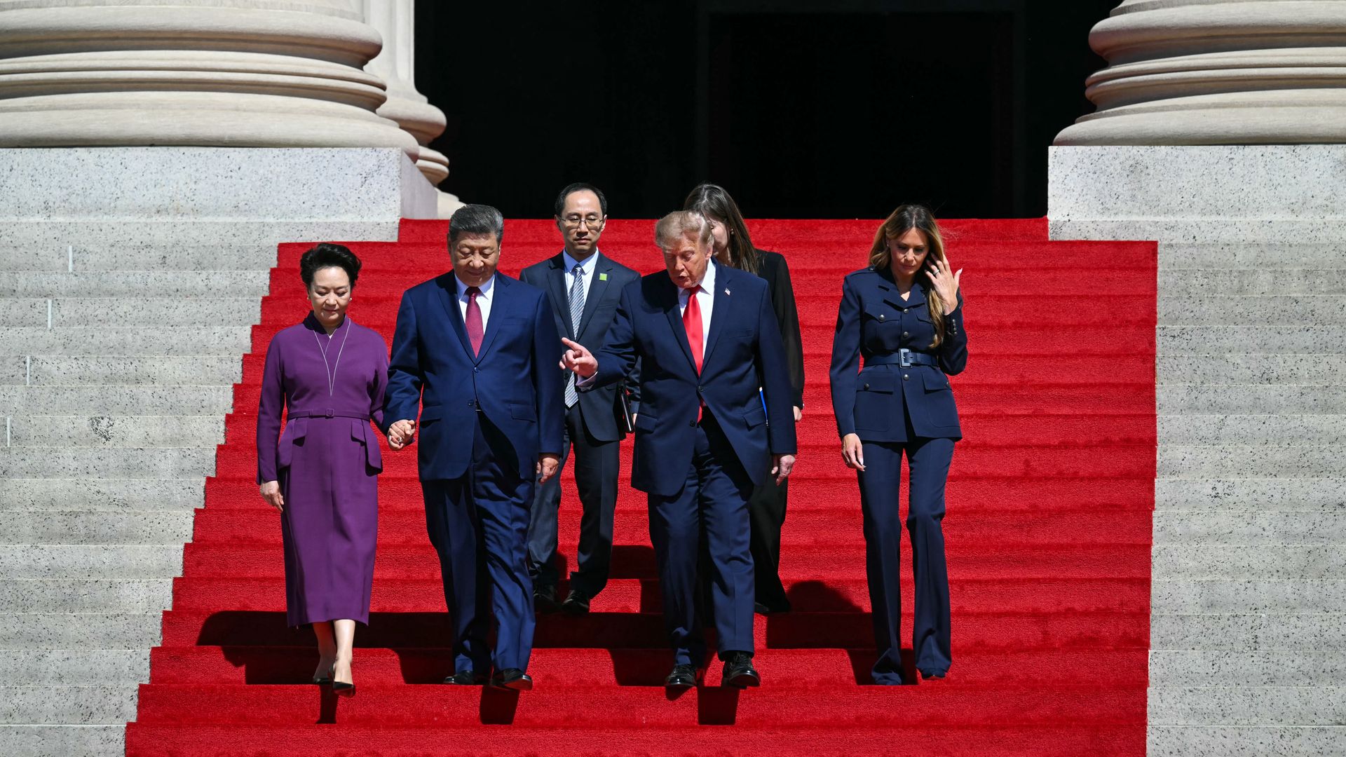 President Trump and China's Xi Jinping descend red-carpeted stairs.