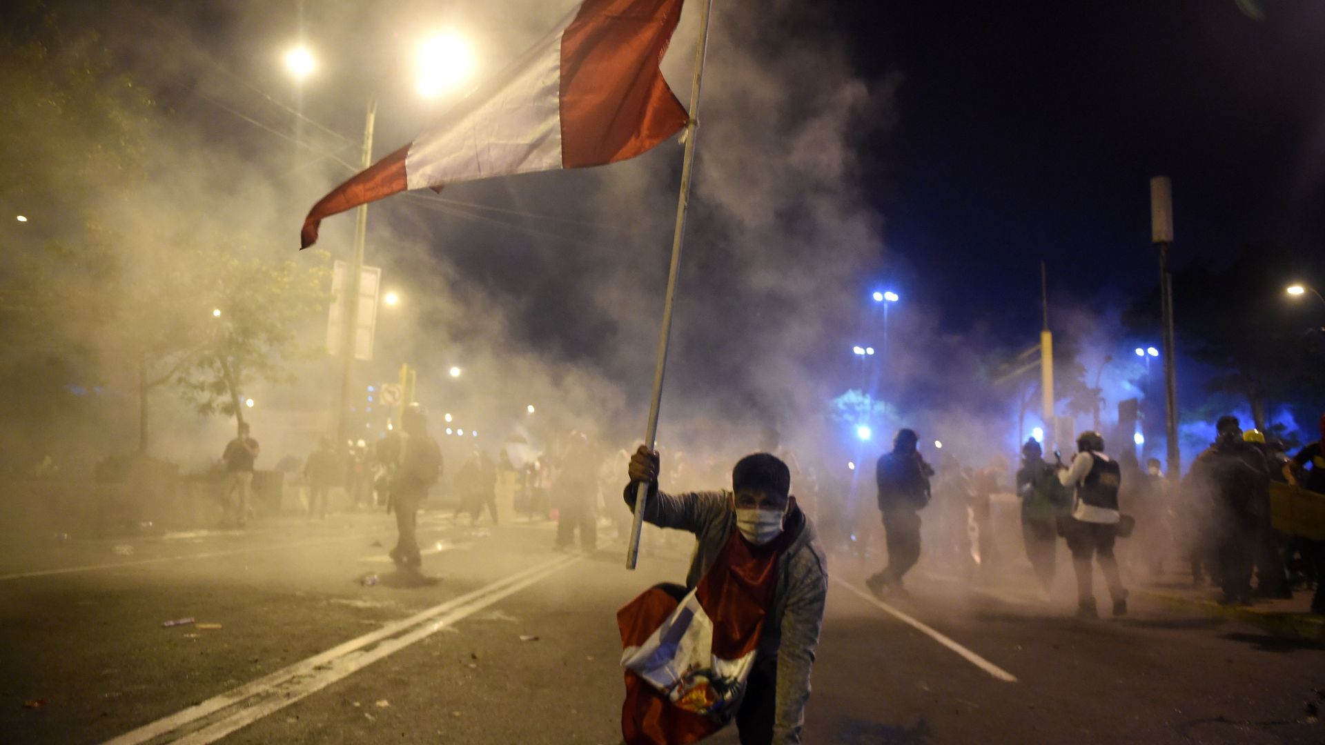 A demonstrator, supporter of Peruvian ousted President Martin Vizcarra, holds a Peruvian flag during a protest against the government of interim president Manuel Merino in Lima on November 14