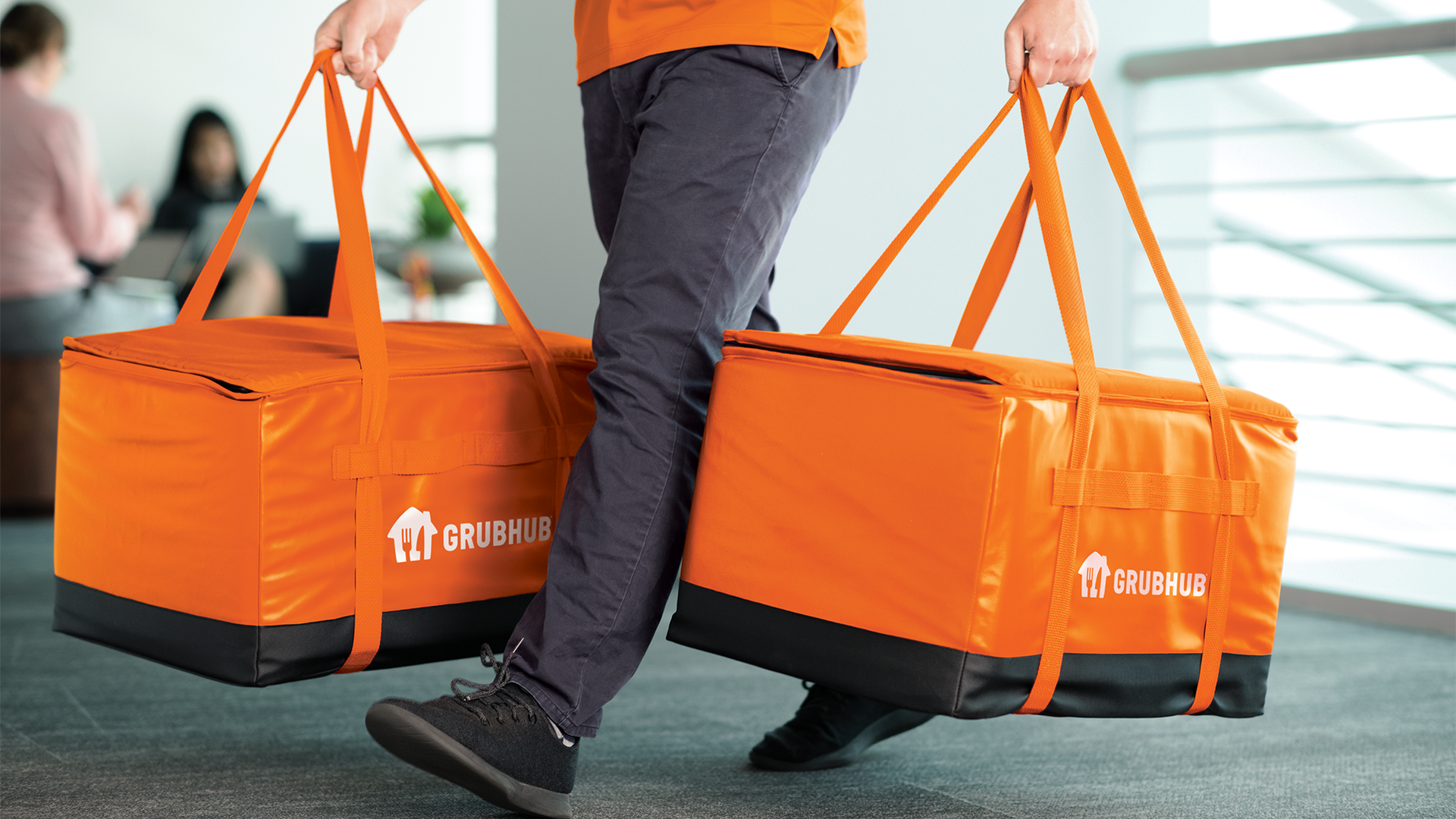 Delivery person holding Grubhub bags