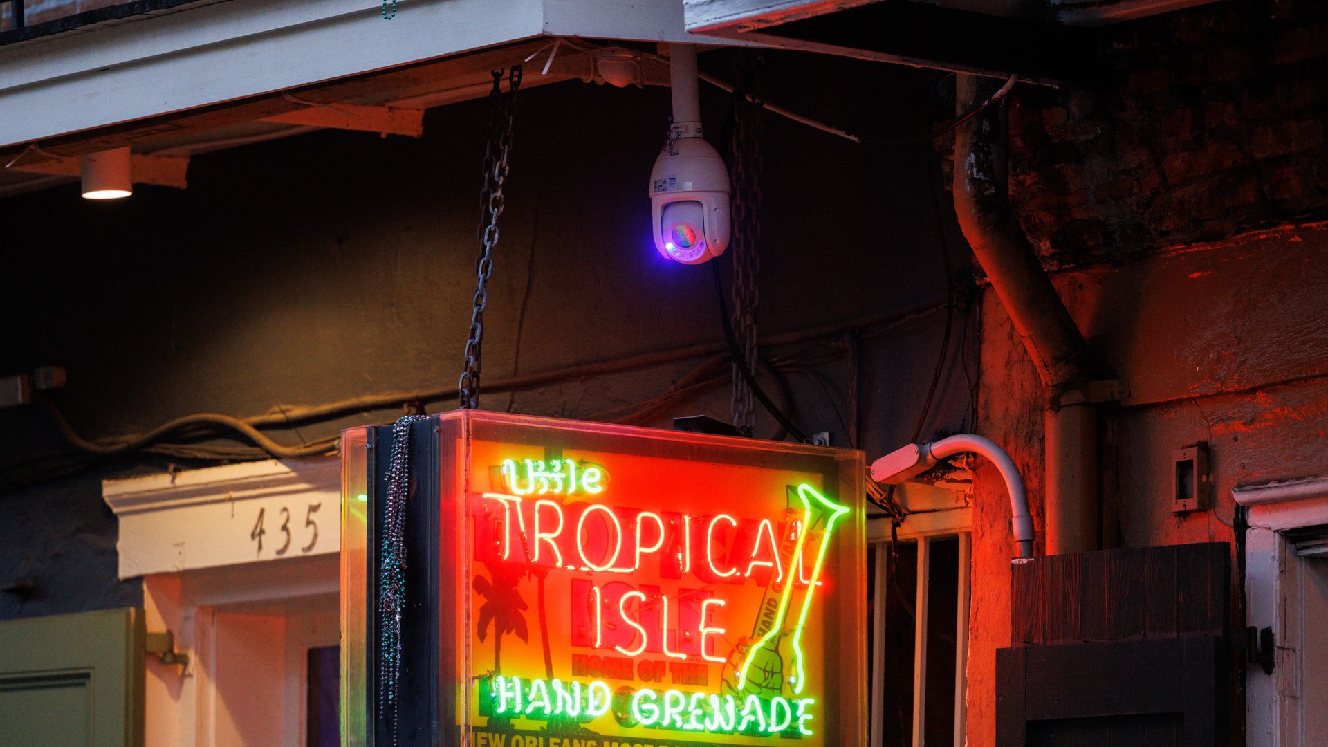 A security camera is seen above a sign for "Tropical Isle" on Bourbon Street.
