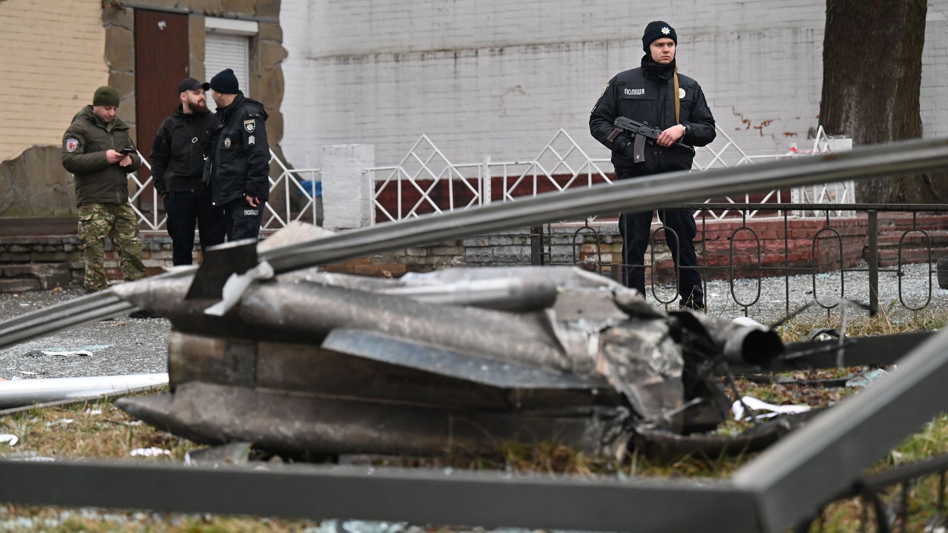 A police officer stands guard by the remains of a shell in Kyiv on Feb. 24.