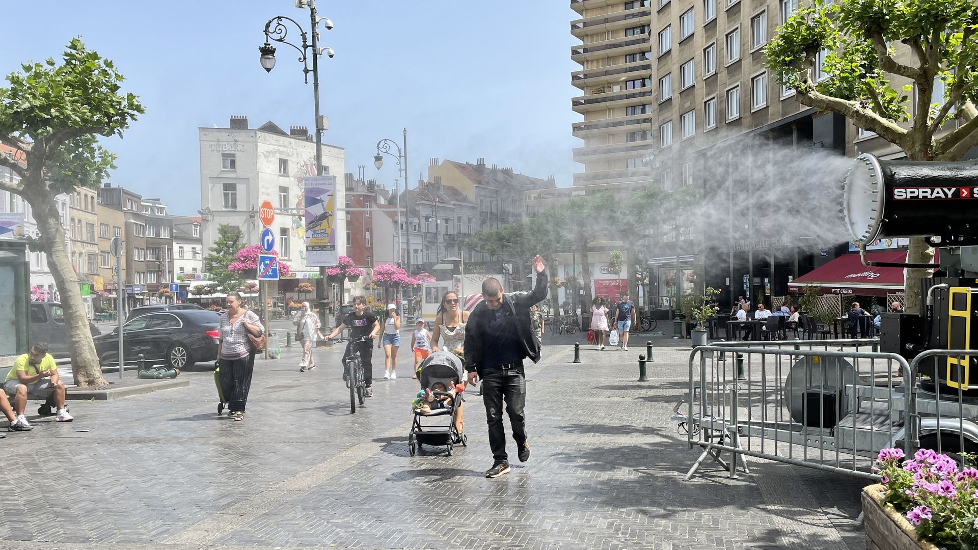 People try to keep cool in a water sprayer during a heat wave in Belgium.