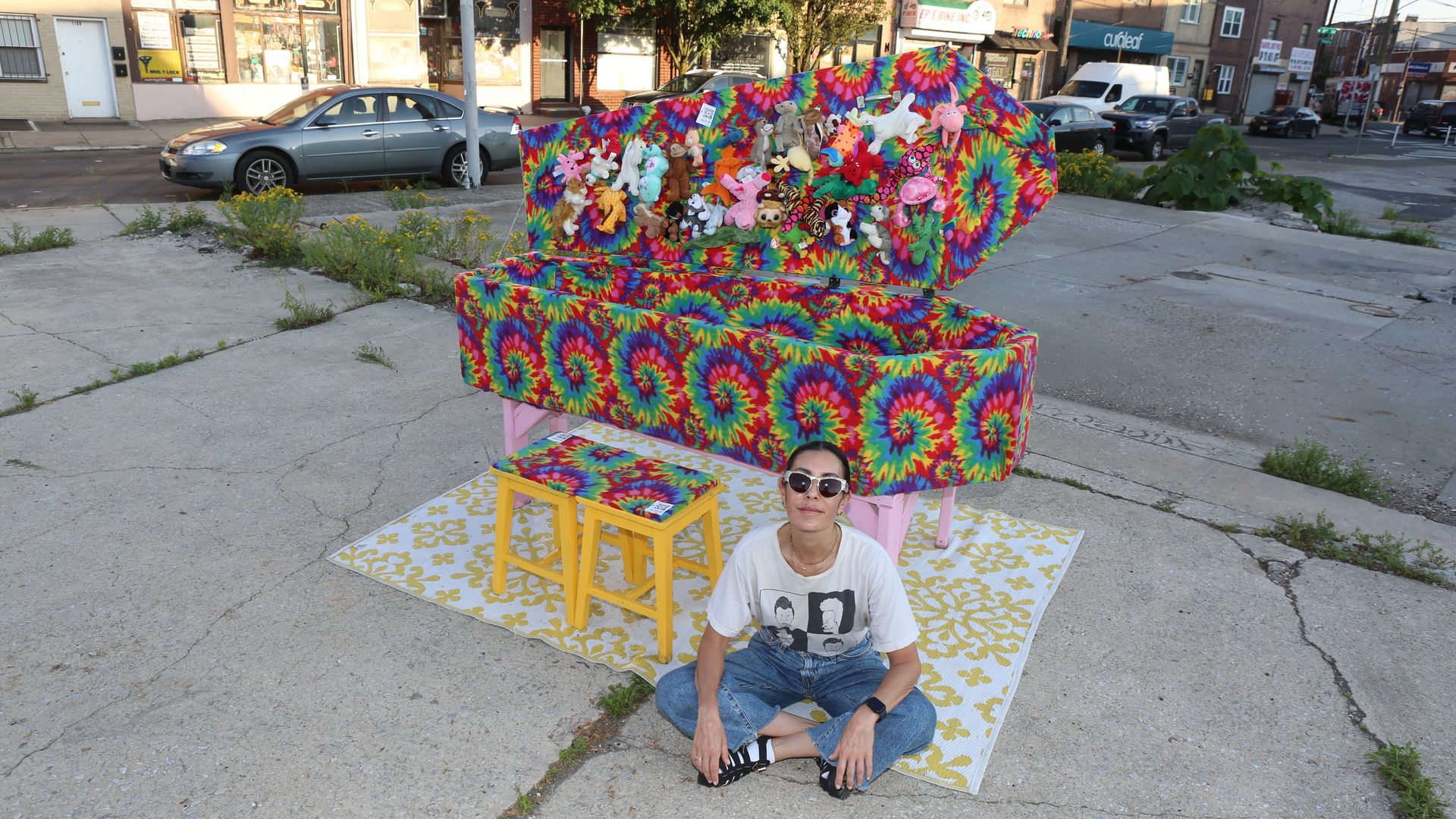 Philly artist Rose Luardo sitting next to her latest guerrilla art installation. It's called "Rave Coffin," a casket wrapped in tie-dye felt.
