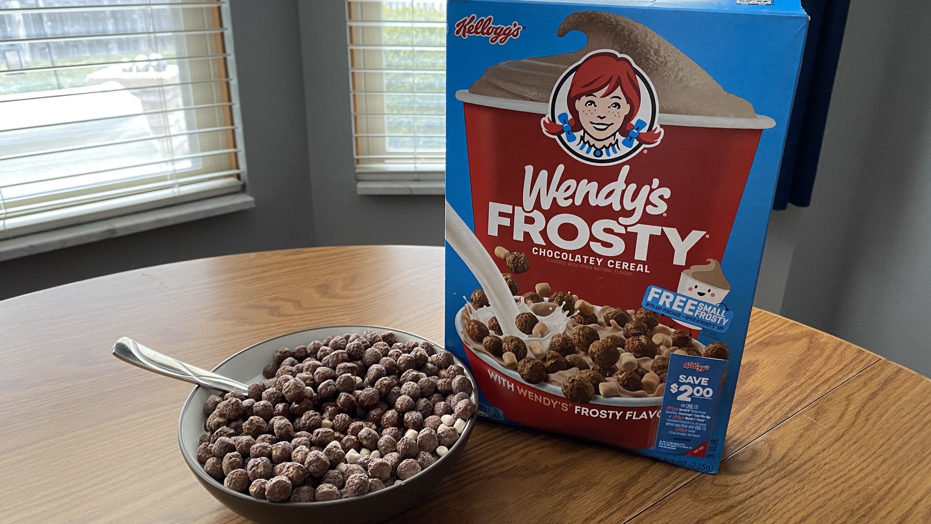 A box of Wendy's Frosty cereal next to a bowl of the cereal with a spoon